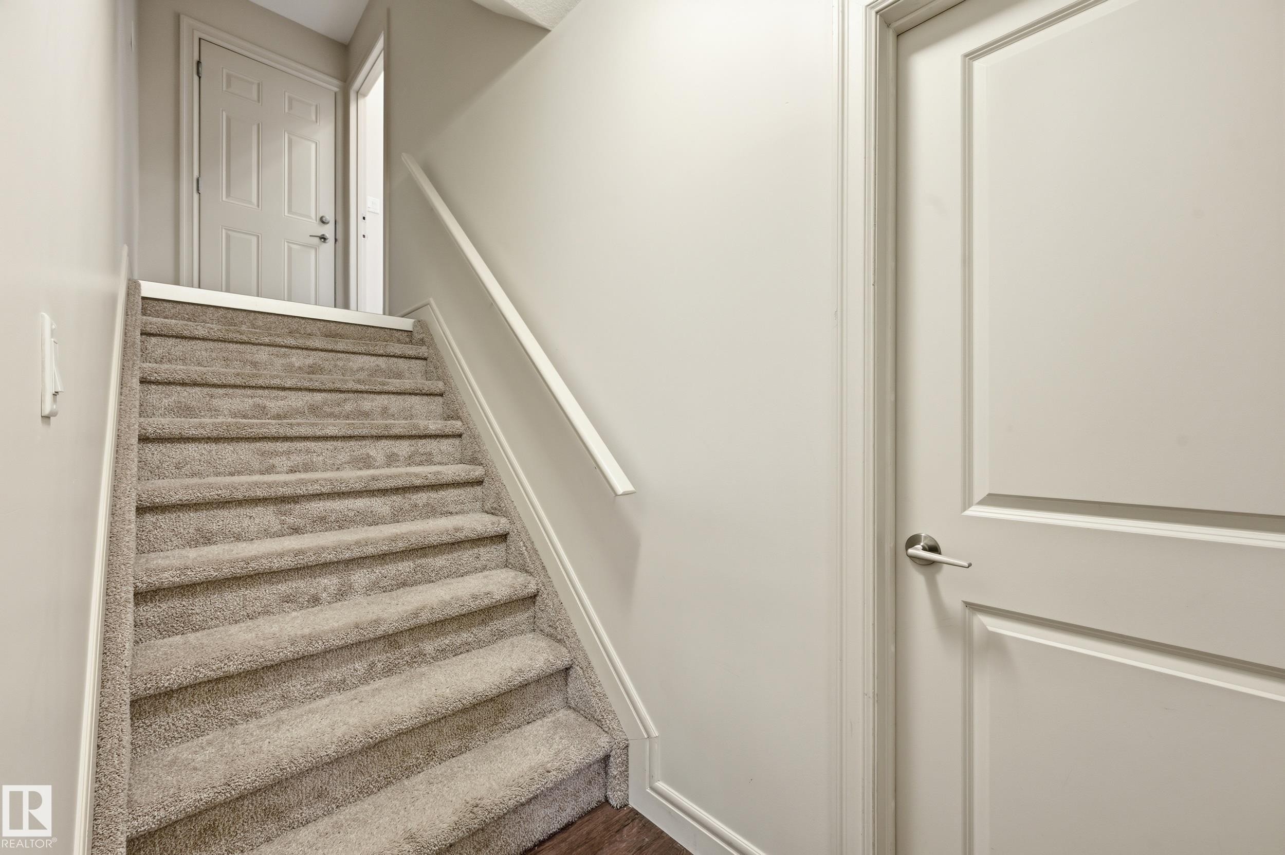 Staircase featuring baseboards and wood finished floors - 1346 Cunningham Drive W, Edmonton, AB - Indoor Photo Showing Other Room