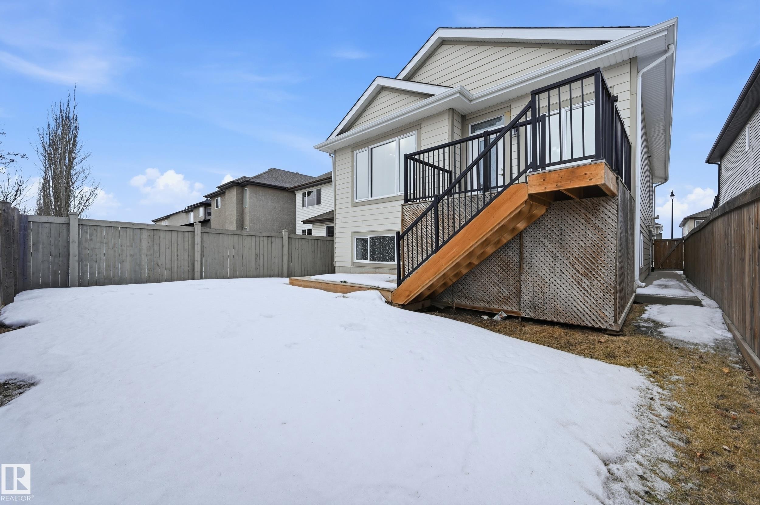Snow covered back of property featuring a fenced backyard and a deck - 1346 Cunningham Drive W, Edmonton, AB - Outdoor