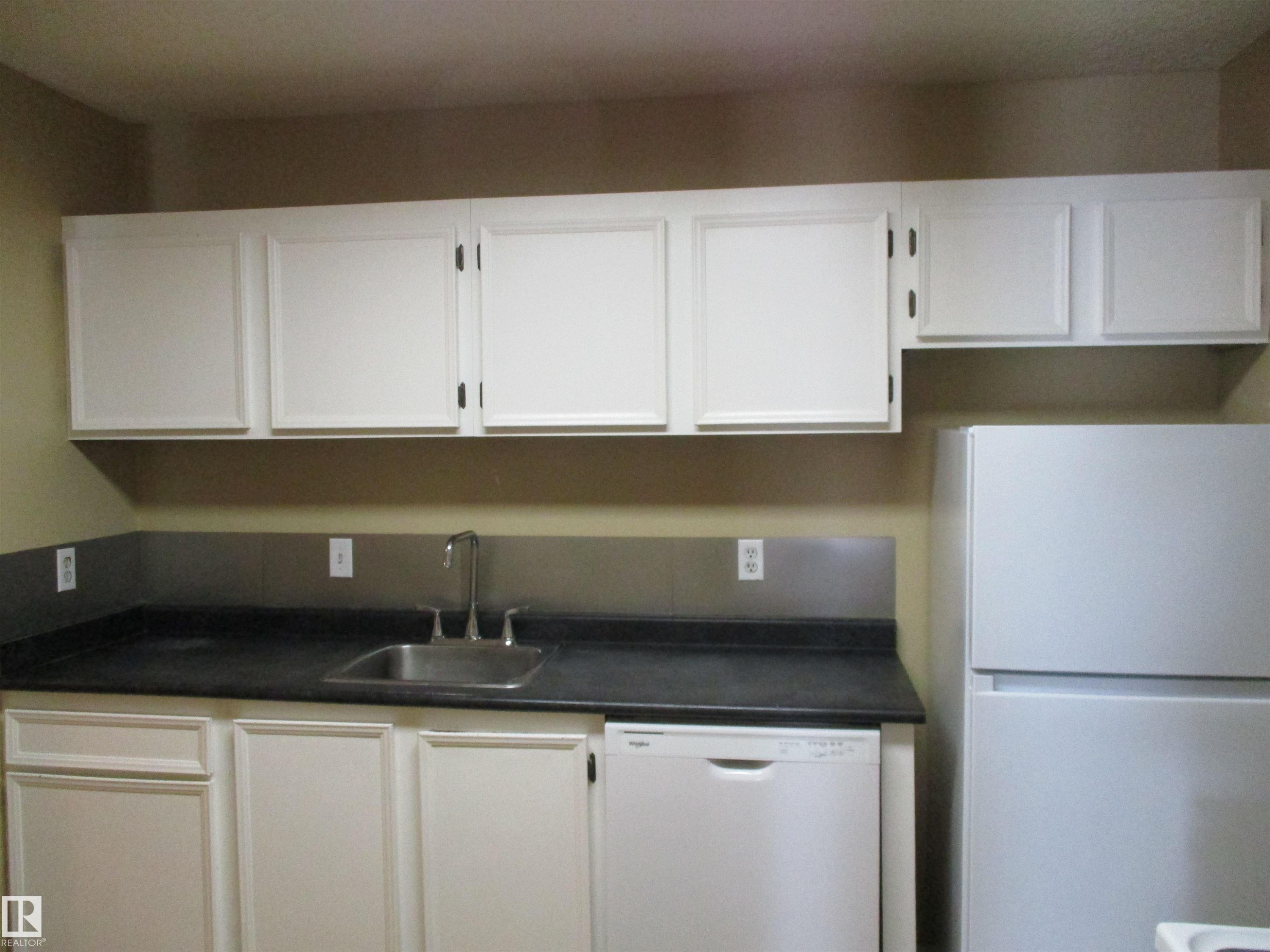 Kitchen with white appliances, dark countertops, and white cabinets - 1186 Saddleback Road, Edmonton, AB - Indoor Photo Showing Kitchen