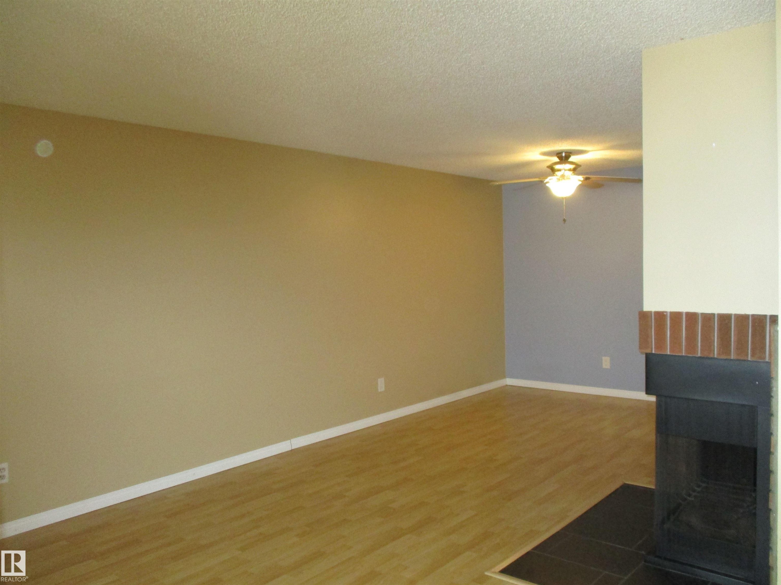 Unfurnished living room featuring light wood-type flooring, ceiling fan, and a textured ceiling - 1186 Saddleback Road, Edmonton, AB - Indoor Photo Showing Other Room