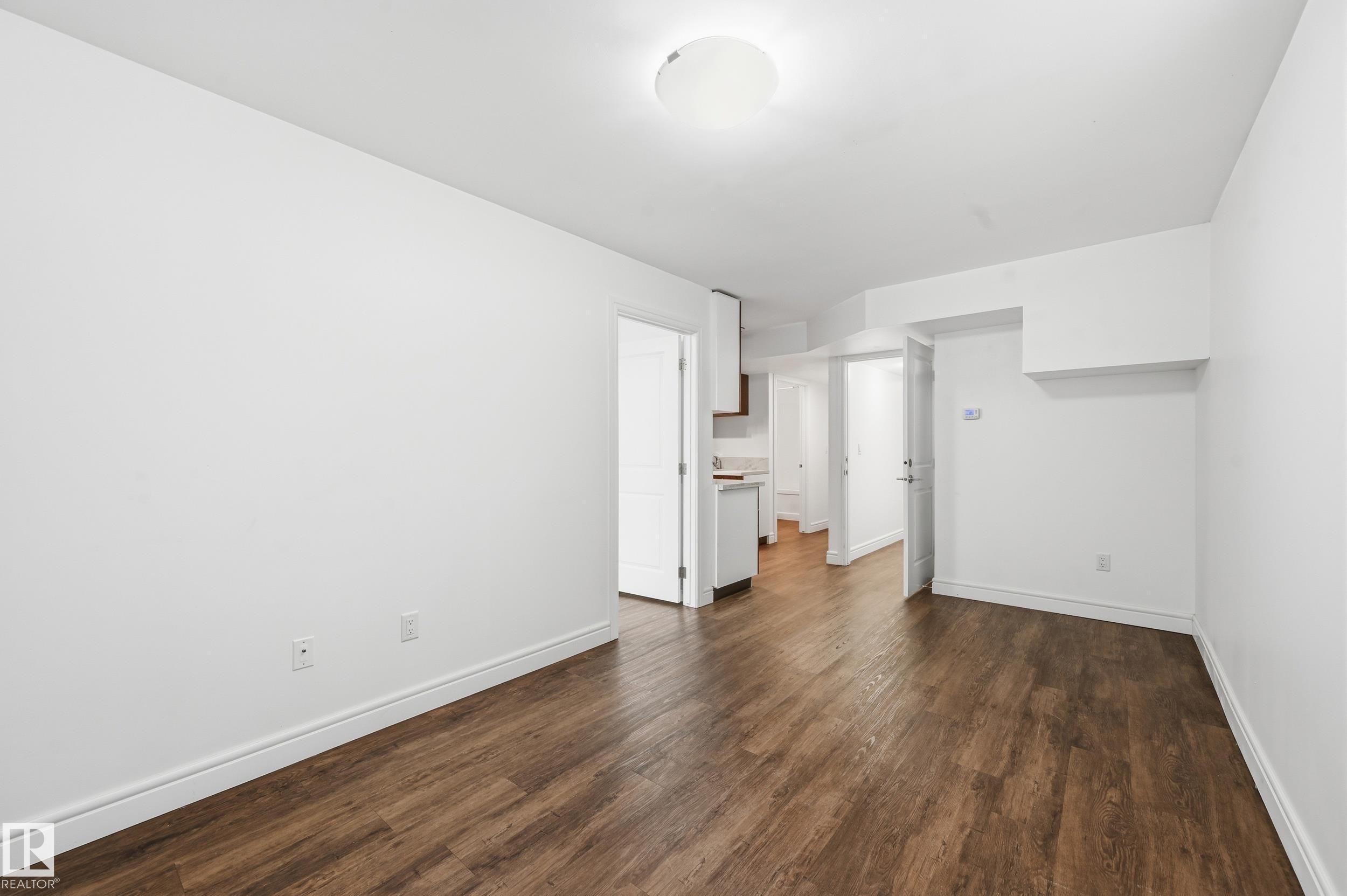 Unfurnished bedroom featuring dark wood-type flooring and baseboards - 1351 Cunningham Drive, Edmonton, AB - Indoor Photo Showing Other Room