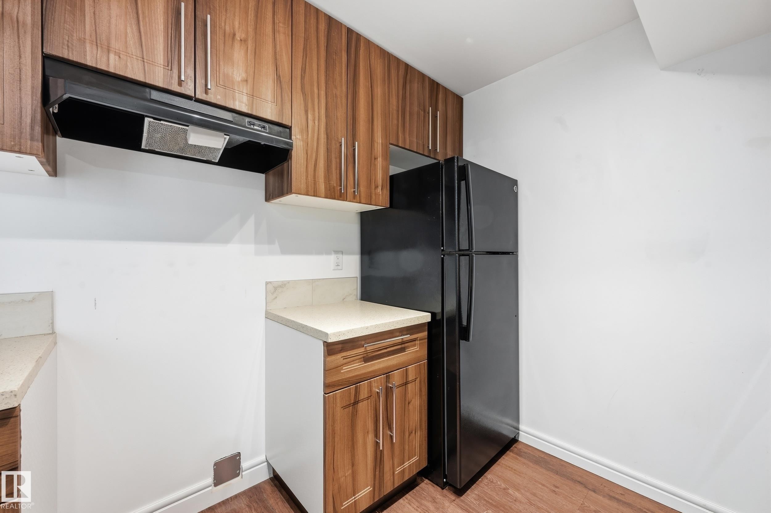Kitchen with wood finish cabinetry, freestanding refrigerator, and light wood-type flooring - 1351 Cunningham Drive, Edmonton, AB - Indoor Photo Showing Kitchen