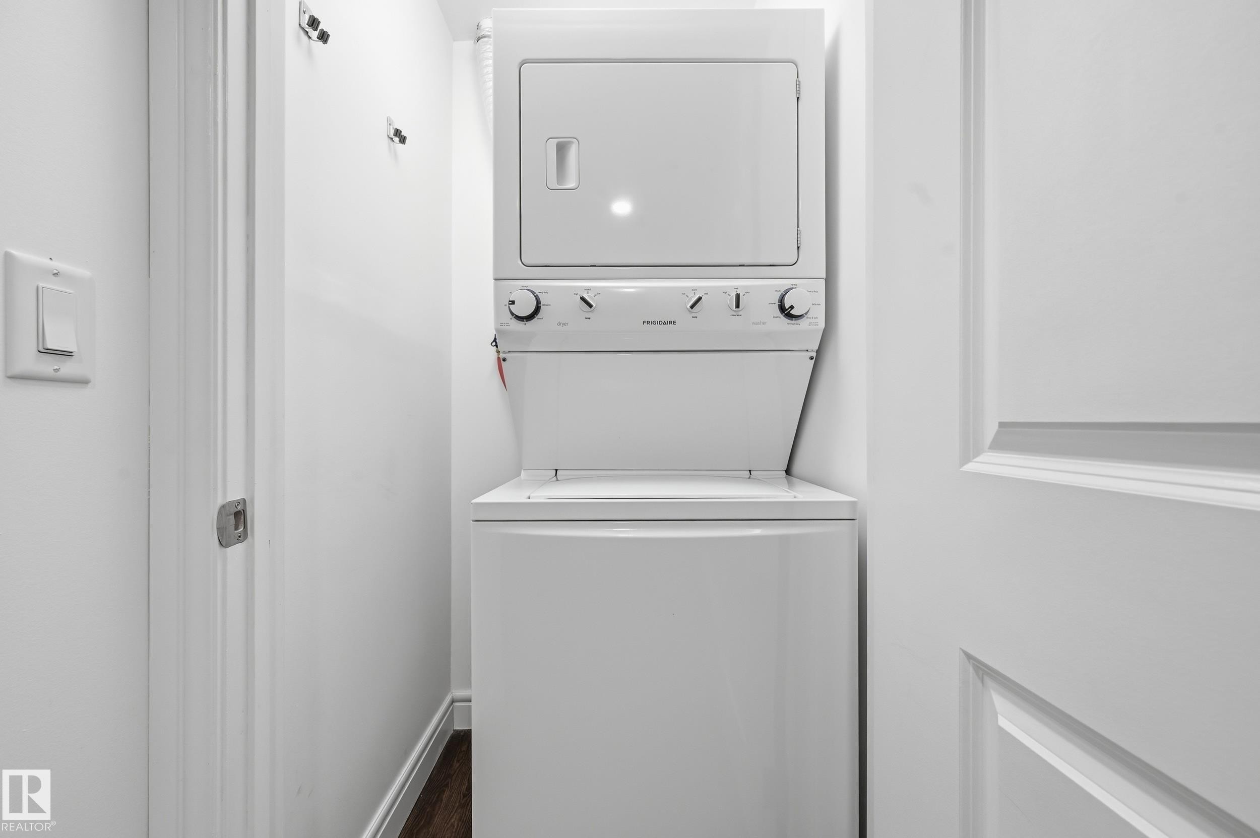 Laundry area with stacked washing machine and dryer and dark wood-style floors - 1351 Cunningham Drive, Edmonton, AB - Indoor Photo Showing Laundry Room