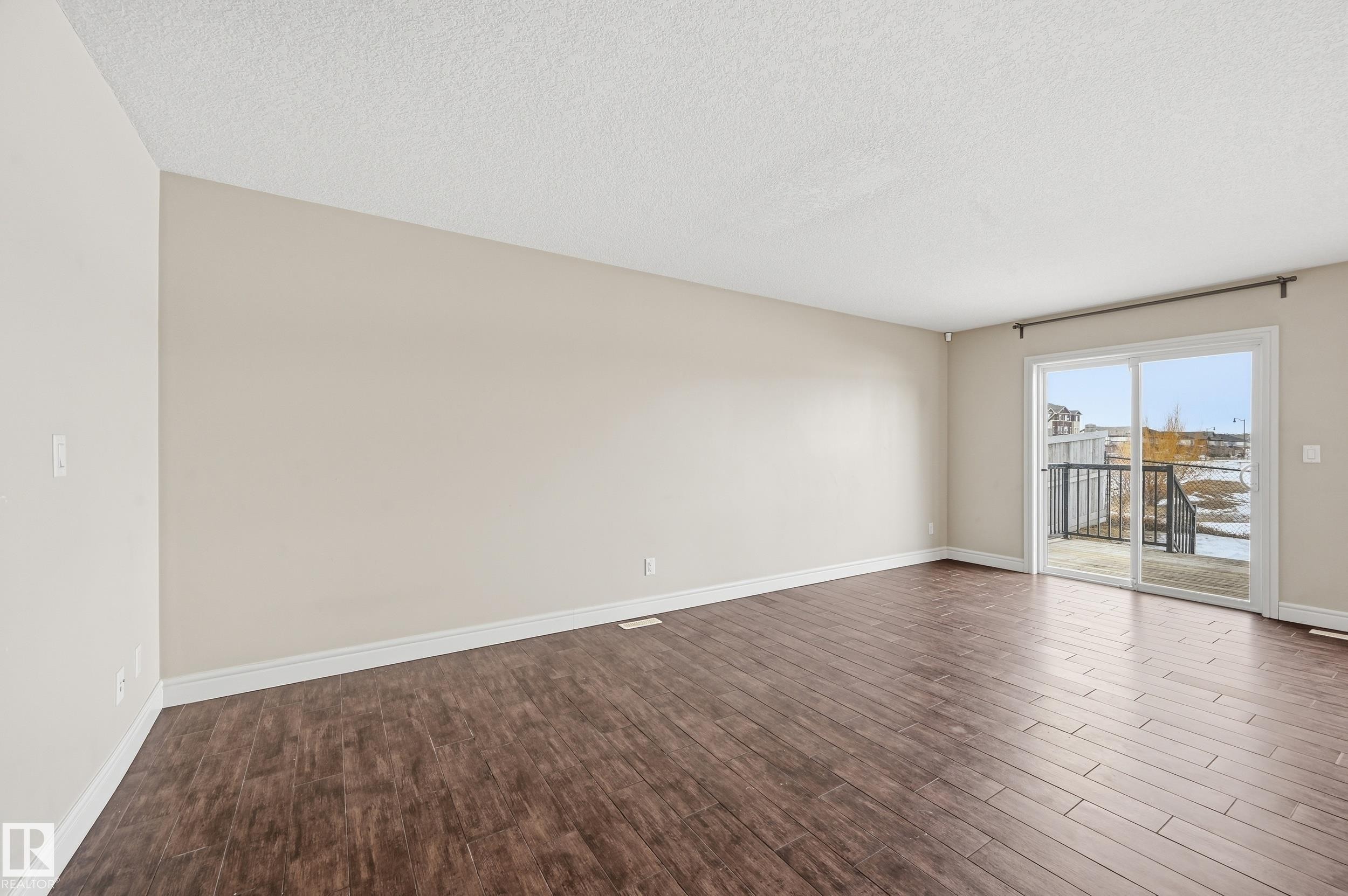 Spare room featuring dark wood-type flooring and a textured ceiling - 1351 Cunningham Drive, Edmonton, AB - Indoor Photo Showing Other Room