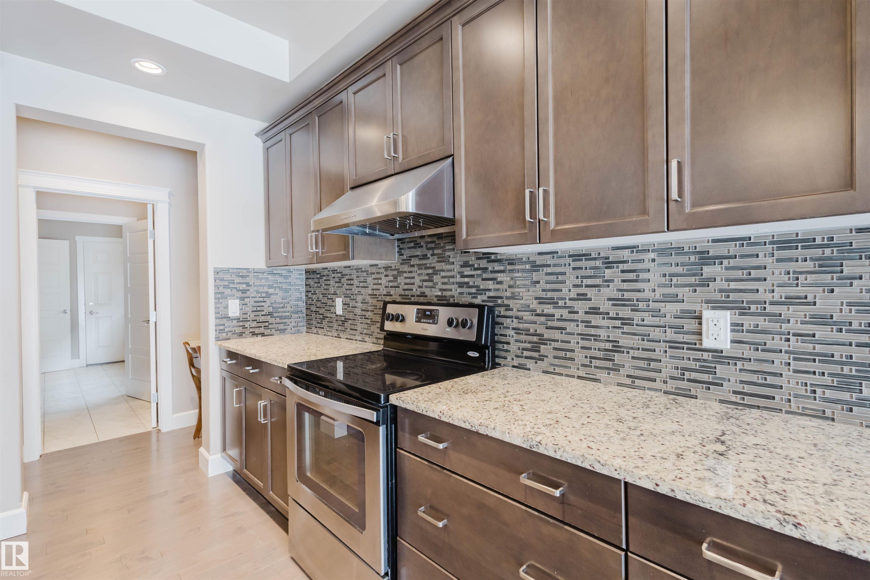 Kitchen featuring electric stove, light stone countertops, backsplash, recessed lighting, and light wood finished floors - 1957 Ainslie Link, Edmonton, AB - Indoor Photo Showing Kitchen With Upgraded Kitchen