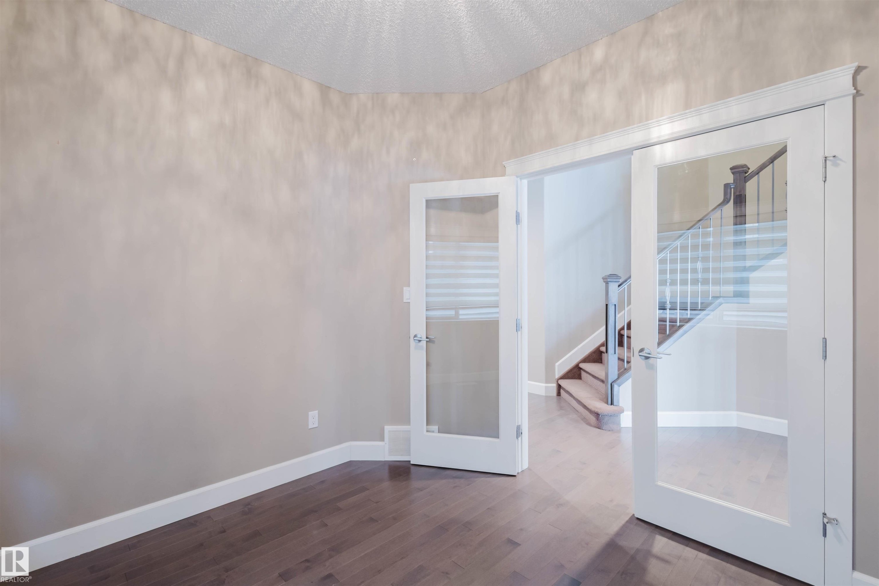 Spare room with french doors, a textured ceiling, and dark wood-type flooring - 1957 Ainslie Link, Edmonton, AB - Indoor Photo Showing Other Room