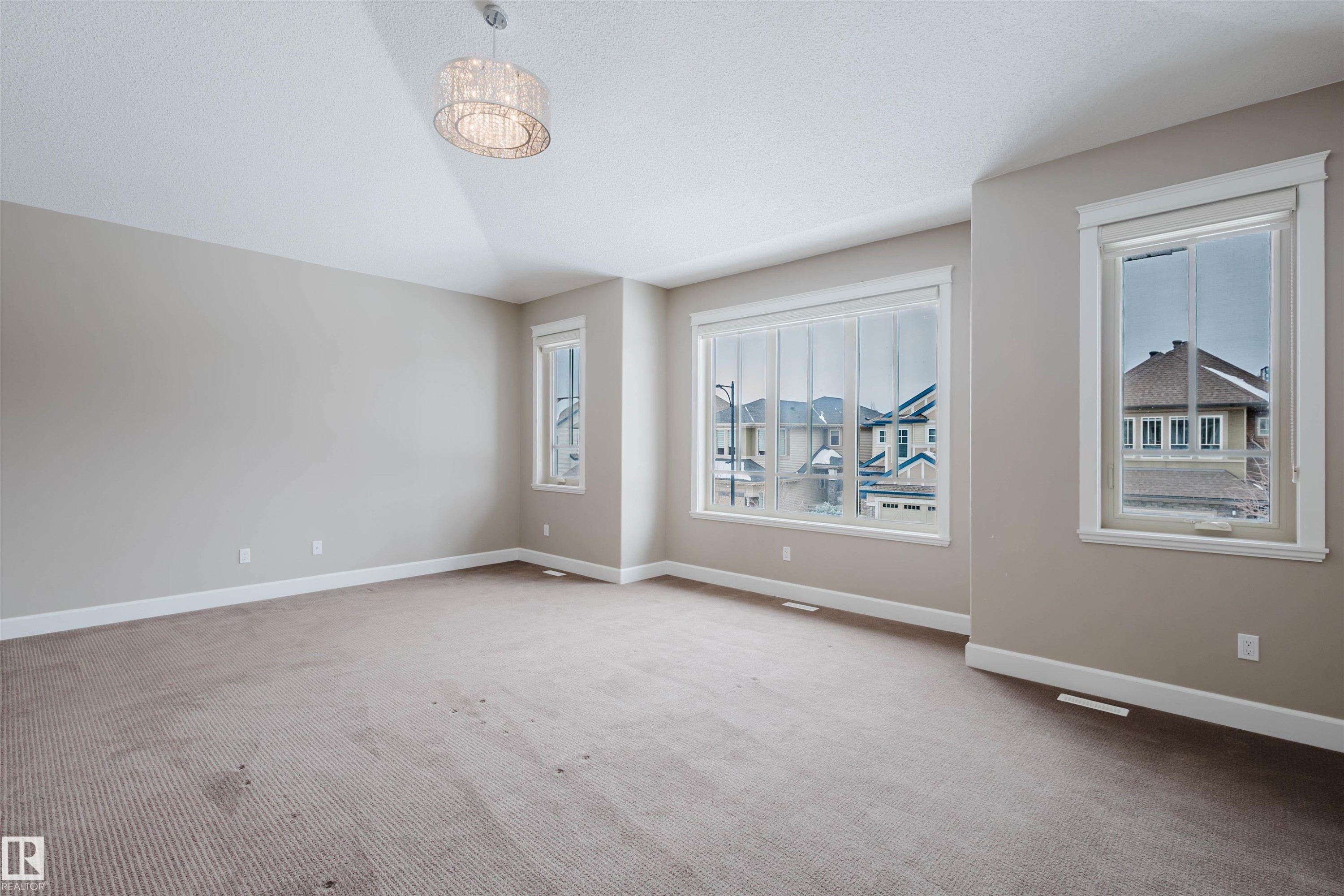 Empty room featuring light colored carpet - 1957 Ainslie Link, Edmonton, AB - Indoor Photo Showing Other Room