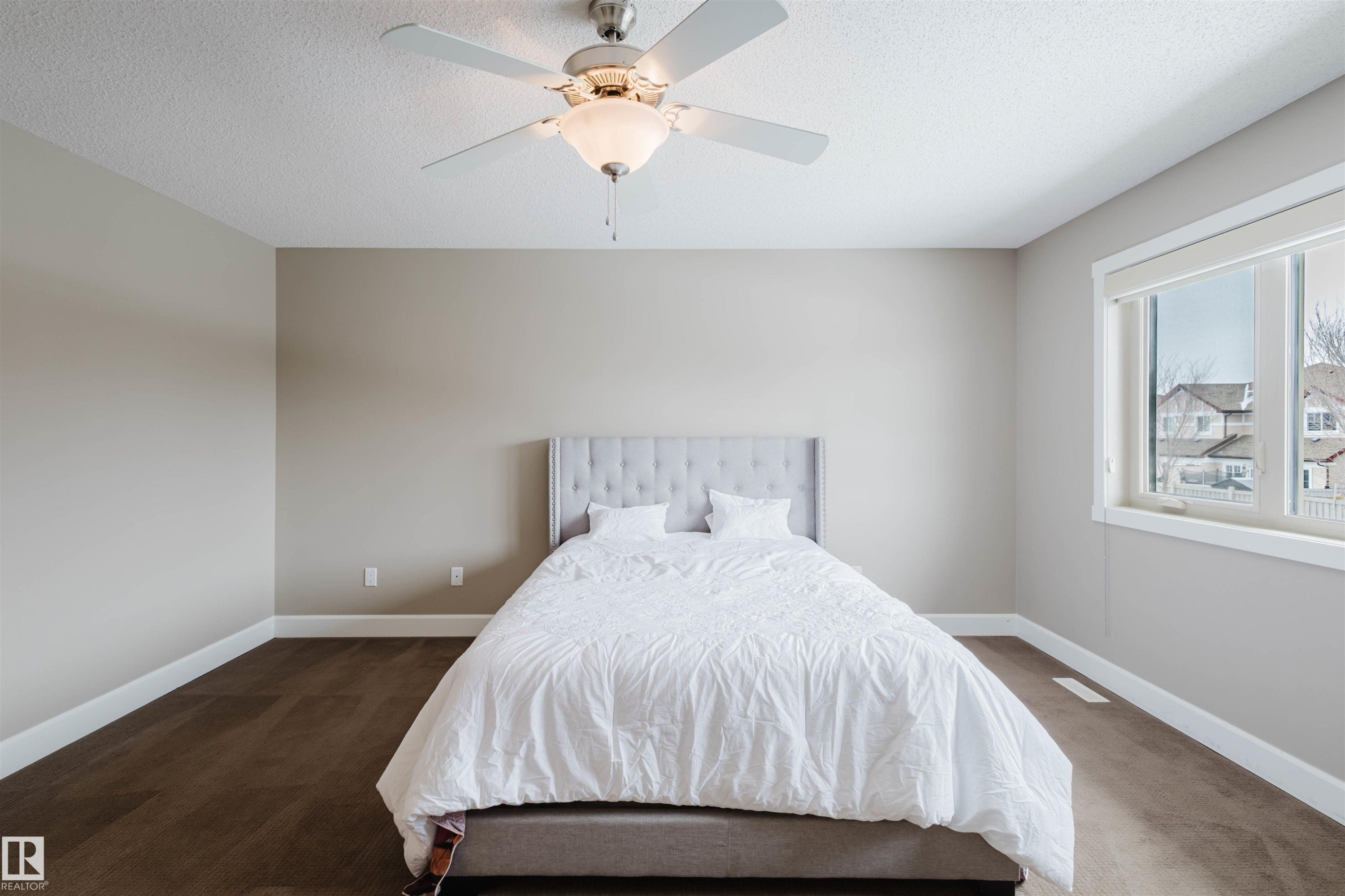 Bedroom featuring ceiling fan, a textured ceiling, and dark carpet - 1957 Ainslie Link, Edmonton, AB - Indoor Photo Showing Bedroom