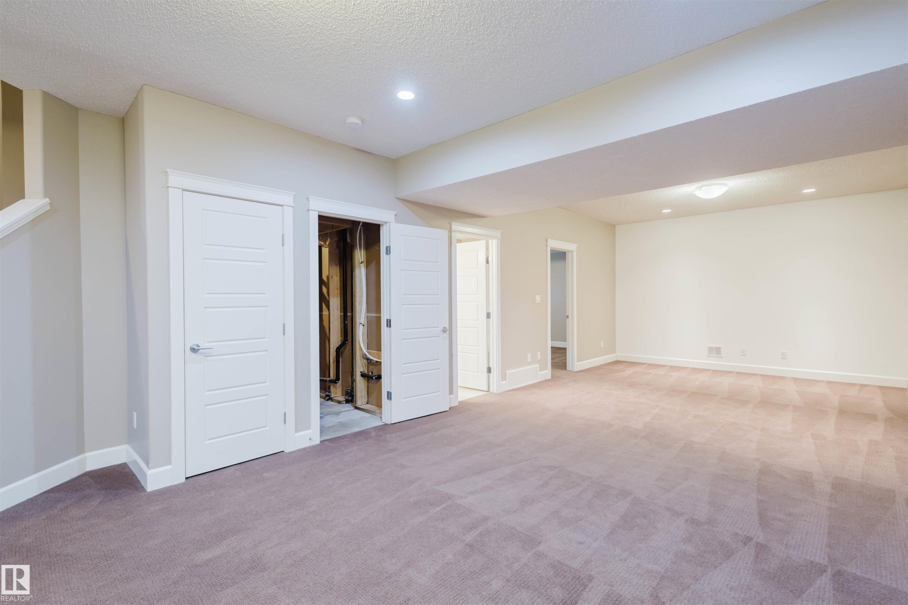 Below grade area featuring light colored carpet, recessed lighting, and a textured ceiling - 1957 Ainslie Link, Edmonton, AB - Indoor Photo Showing Other Room