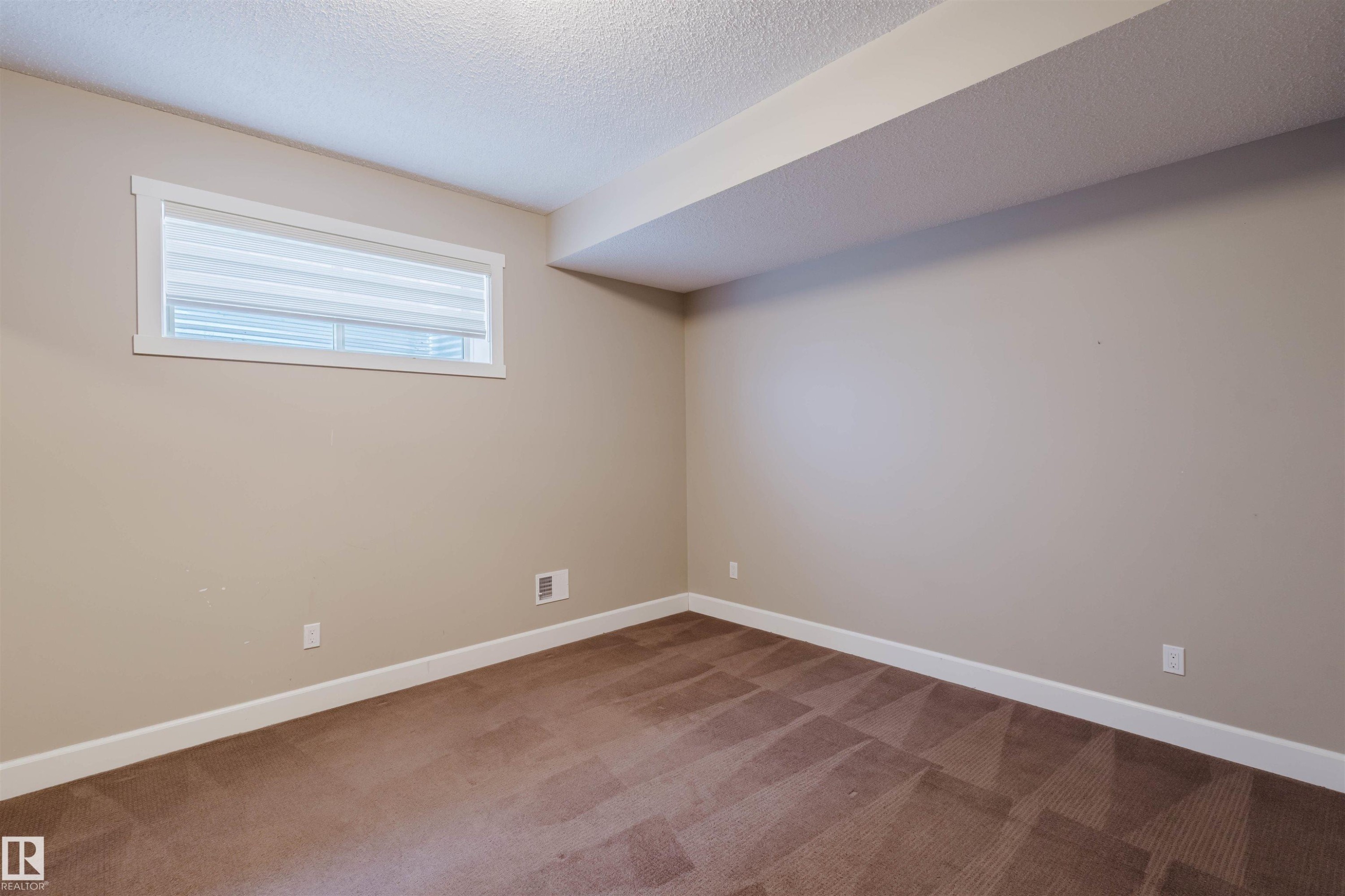 Unfurnished room featuring light carpet and a textured ceiling - 1957 Ainslie Link, Edmonton, AB - Indoor Photo Showing Other Room
