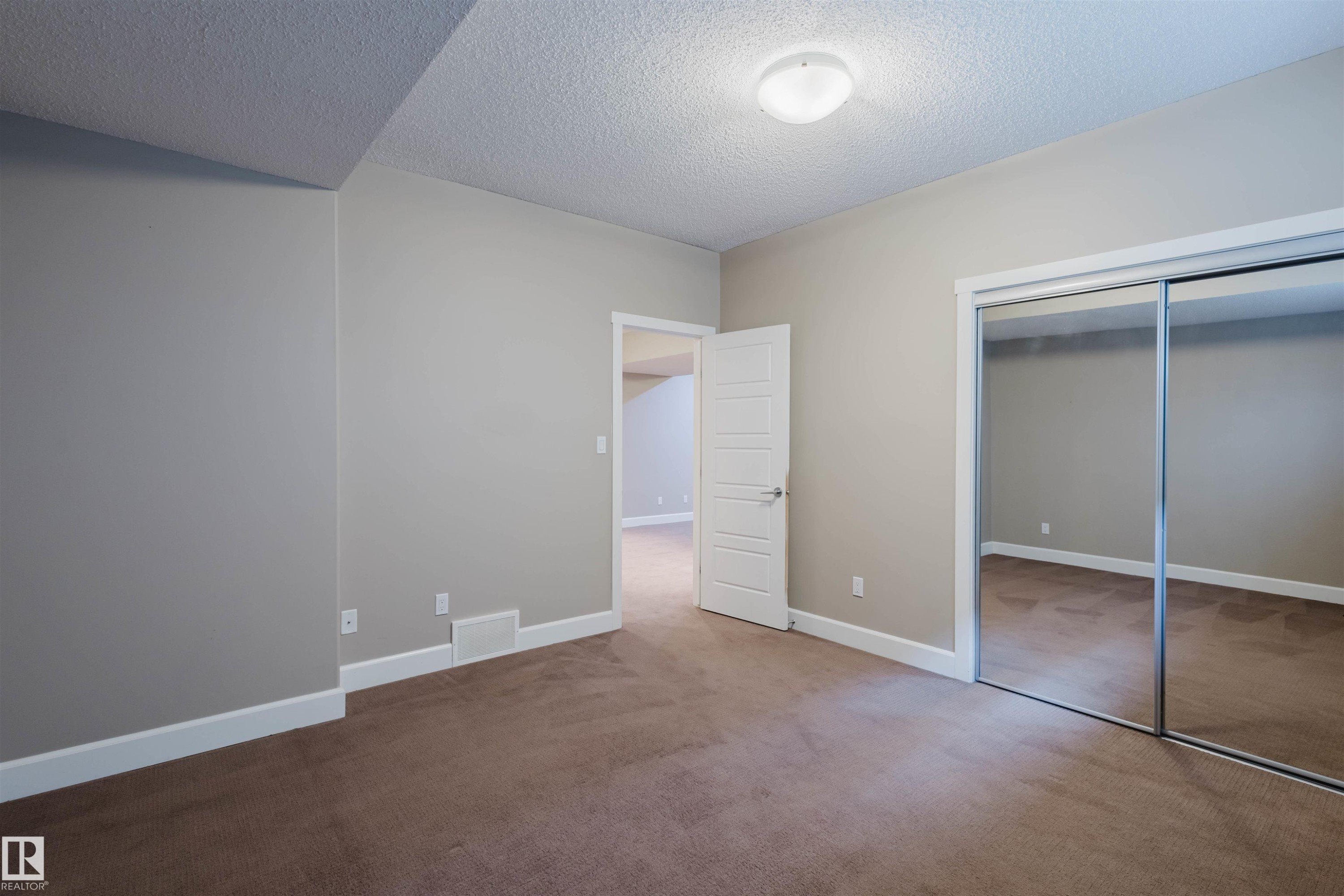Unfurnished bedroom with carpet flooring, a textured ceiling, and a closet - 1957 Ainslie Link, Edmonton, AB - Indoor Photo Showing Other Room