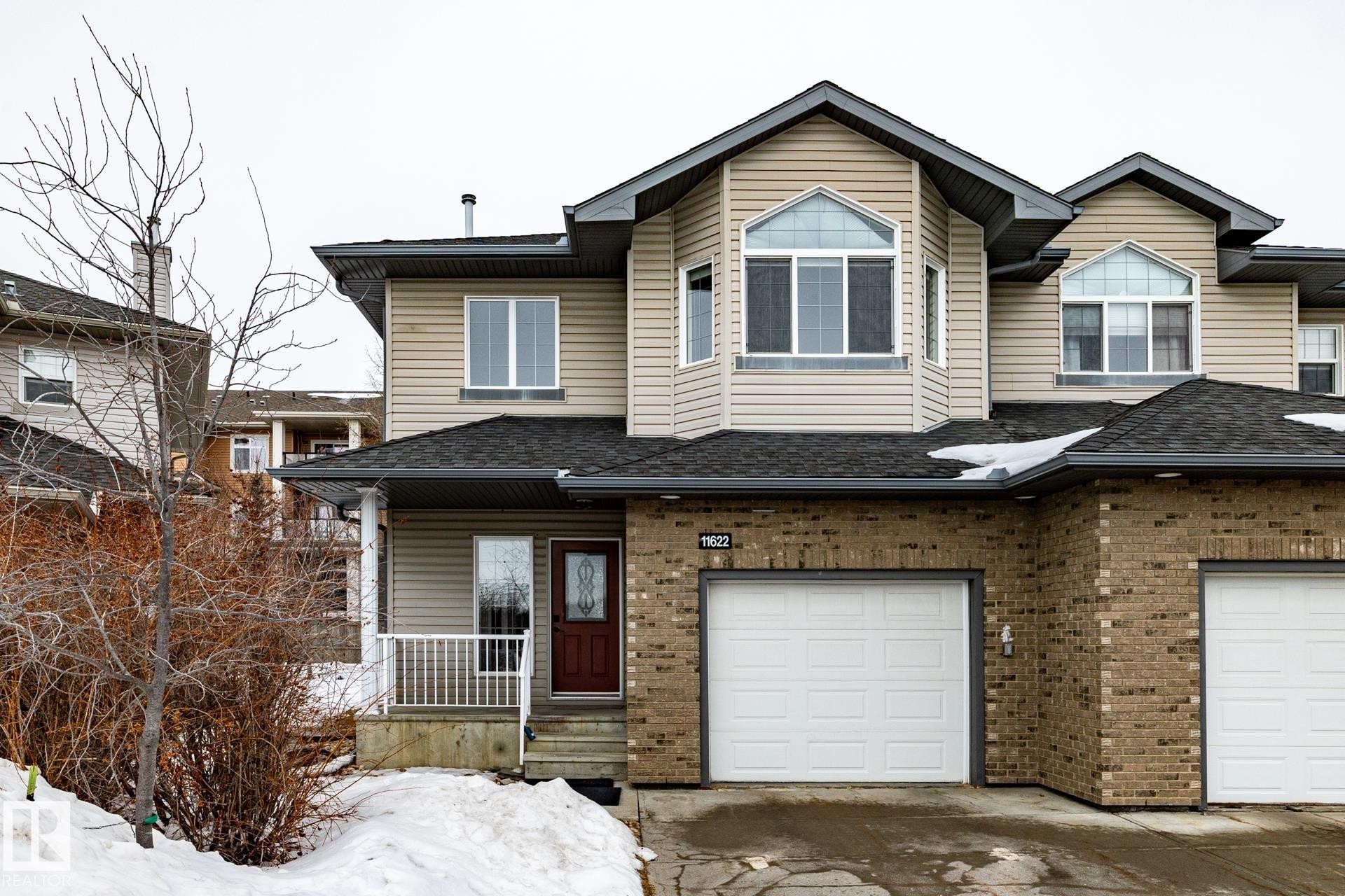 View of front of property with a porch, brick siding, a garage, and a shingled roof - 11622 11 Avenue, Edmonton, AB - Outdoor With Facade