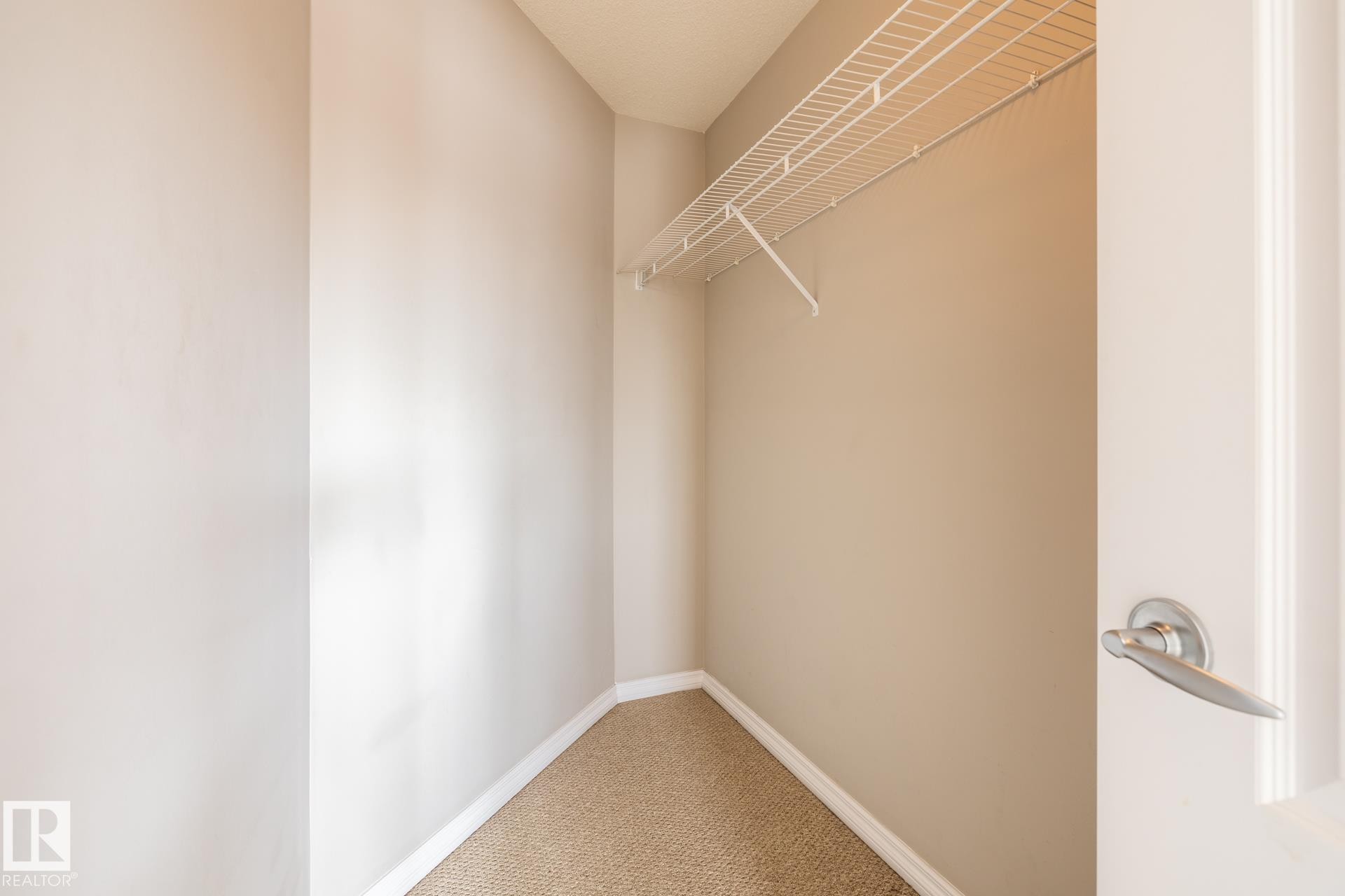 Walk in closet featuring light colored carpet - 11622 11 Avenue, Edmonton, AB - Indoor