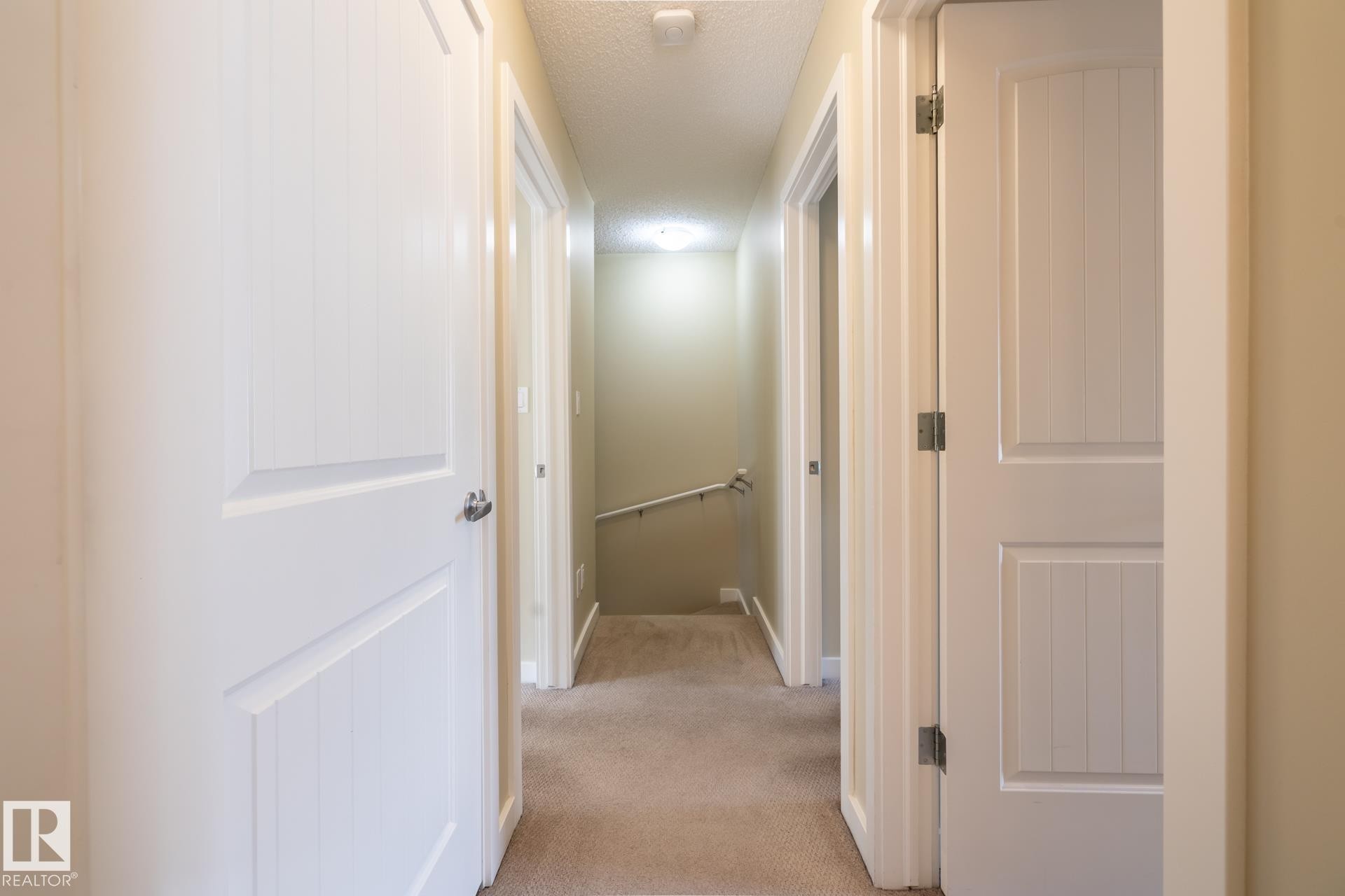 Hallway featuring light carpet, a textured ceiling, and an upstairs landing - 21 655 Watt Boulevard, Edmonton, AB - Indoor Photo Showing Other Room