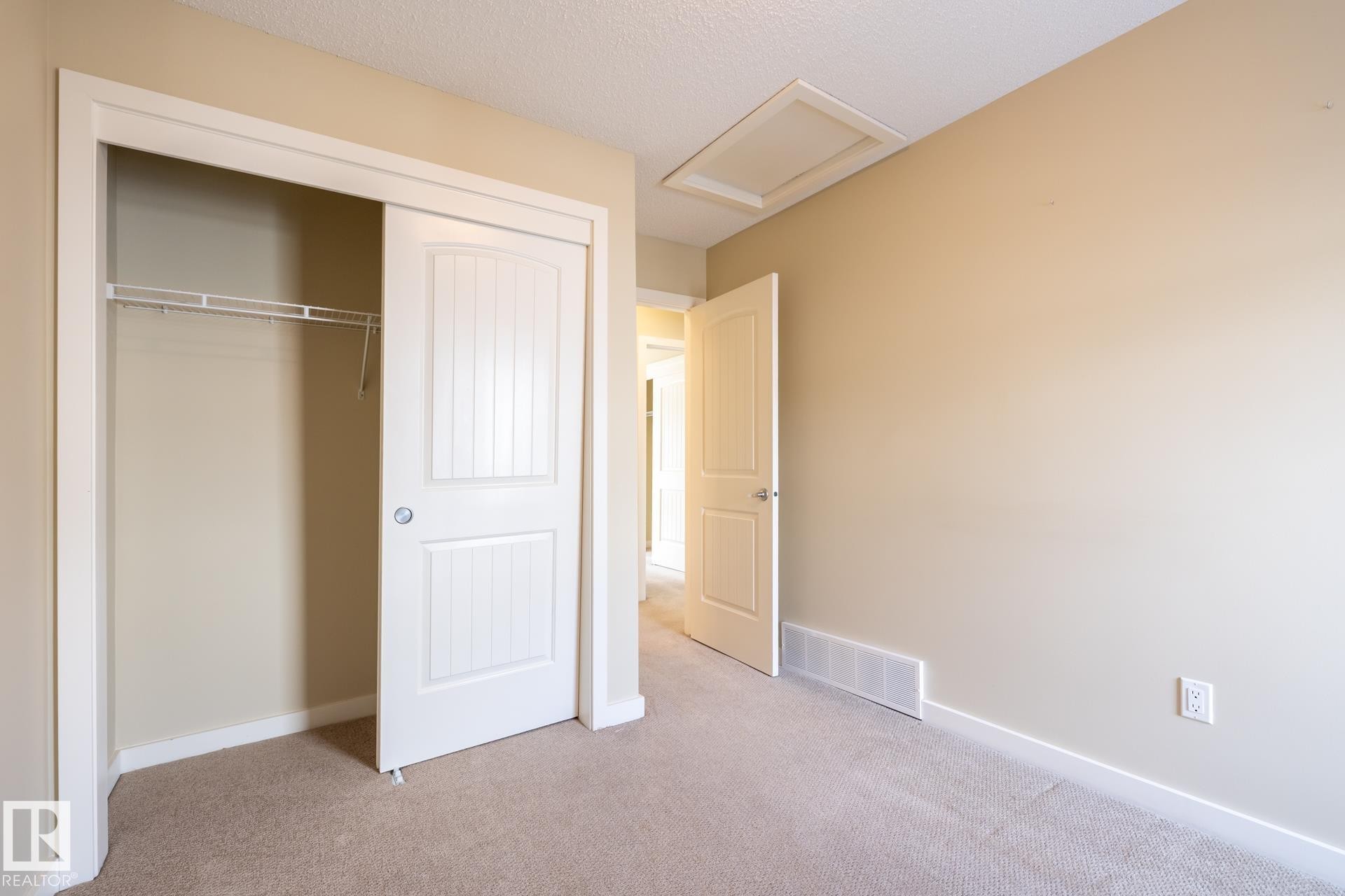 Unfurnished bedroom with light colored carpet, a closet, and a textured ceiling - 21 655 Watt Boulevard, Edmonton, AB - Indoor Photo Showing Other Room