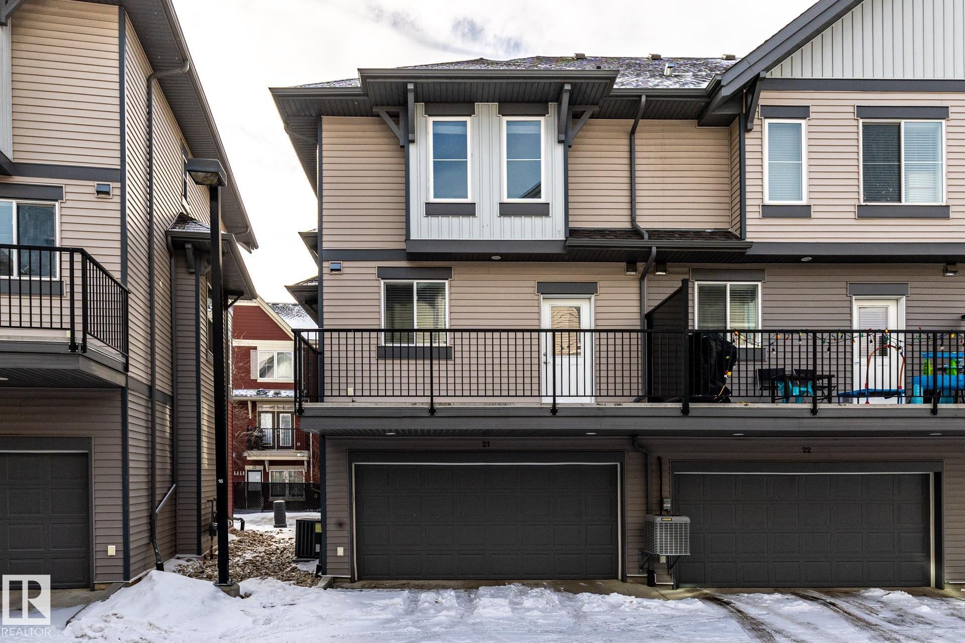 Snow covered house with a balcony, board and batten siding, and a garage - 21 655 Watt Boulevard, Edmonton, AB - Outdoor With Balcony