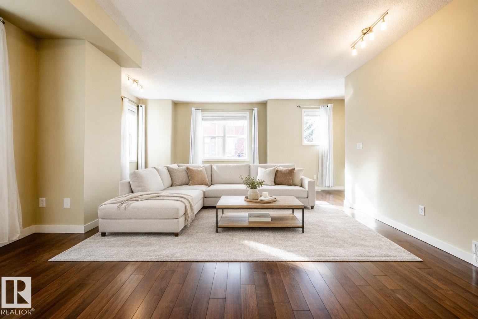 Living room with track lighting, dark wood-style floors, and a textured ceiling - 21 655 Watt Boulevard, Edmonton, AB - Indoor Photo Showing Living Room