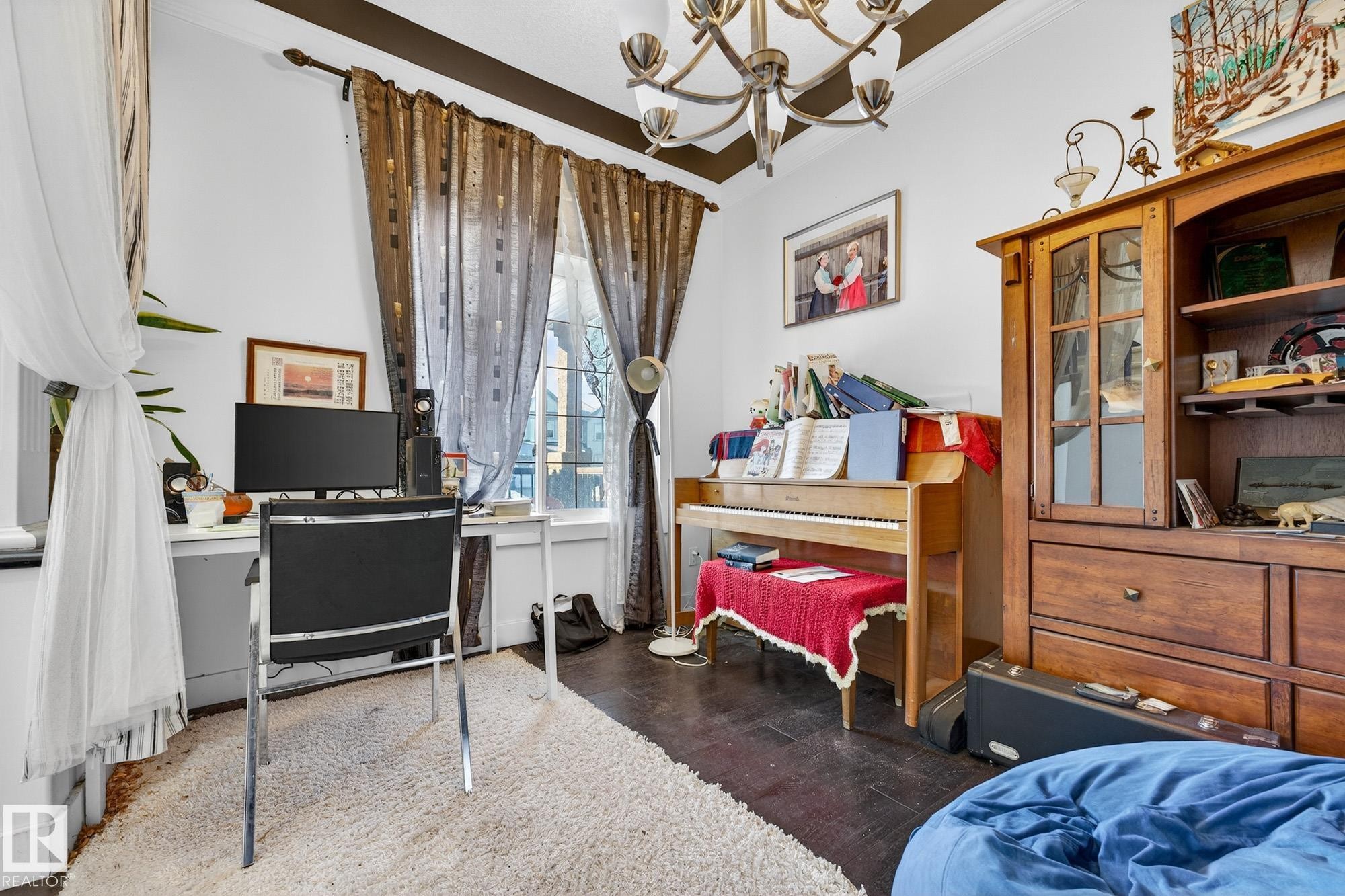 Bedroom featuring suspended lighting, a desk, dark wood-style flooring, and ornamental molding - 1660 Malone Way, Edmonton, AB - Indoor