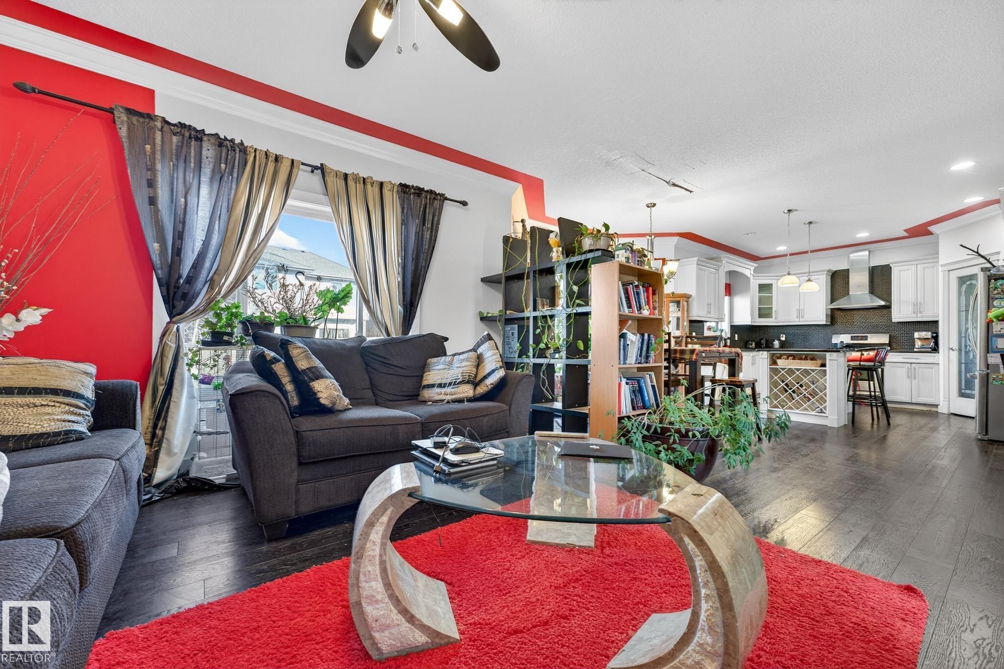 Living area with crown molding, dark wood-style flooring, ceiling fan, and recessed lighting - 1660 Malone Way, Edmonton, AB - Indoor Photo Showing Living Room