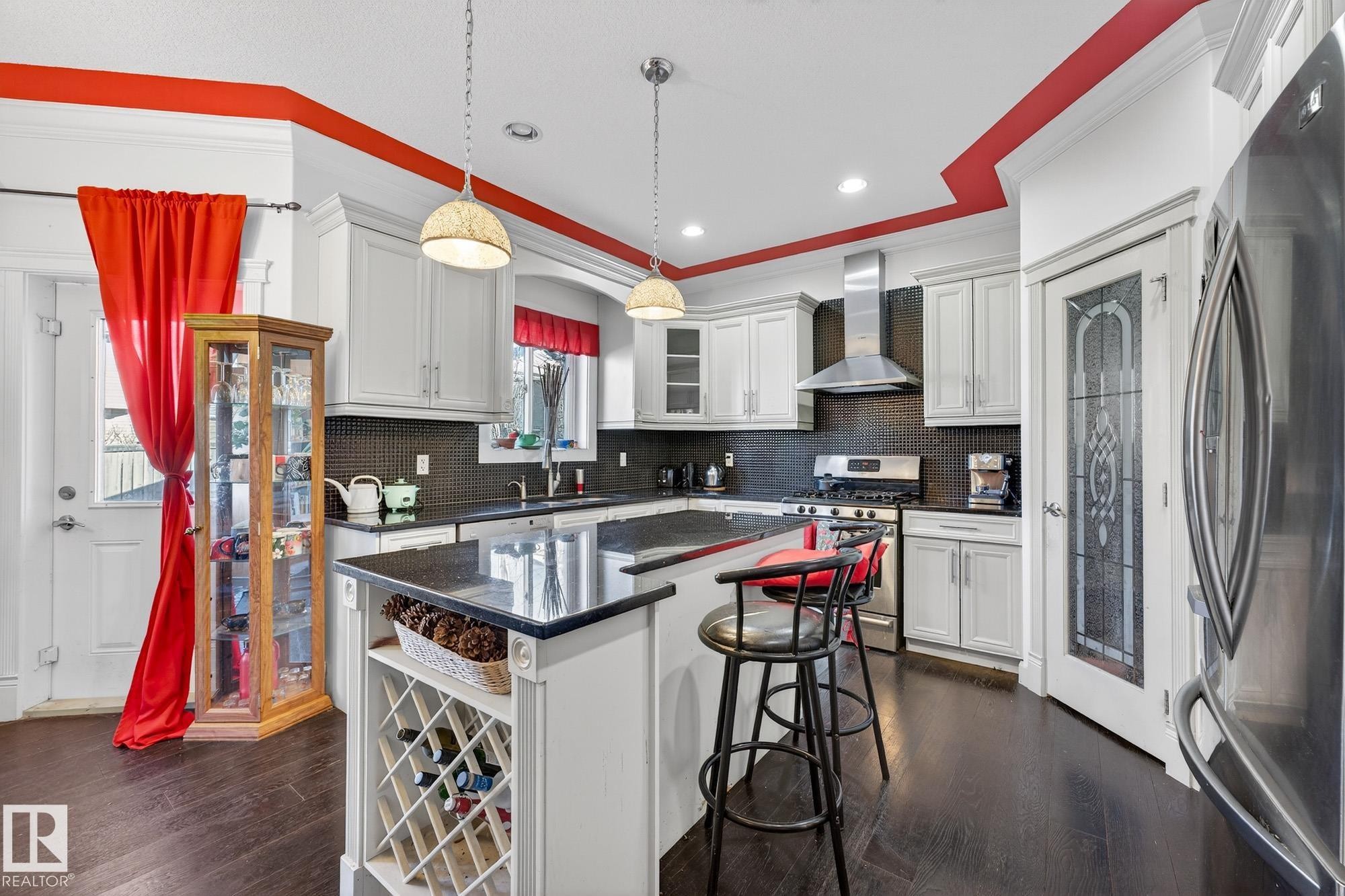 Kitchen featuring stainless steel appliances, crown molding, glass fronted cabinets, dark wood-style floors, and white cabinetry - 1660 Malone Way, Edmonton, AB - Indoor Photo Showing Kitchen