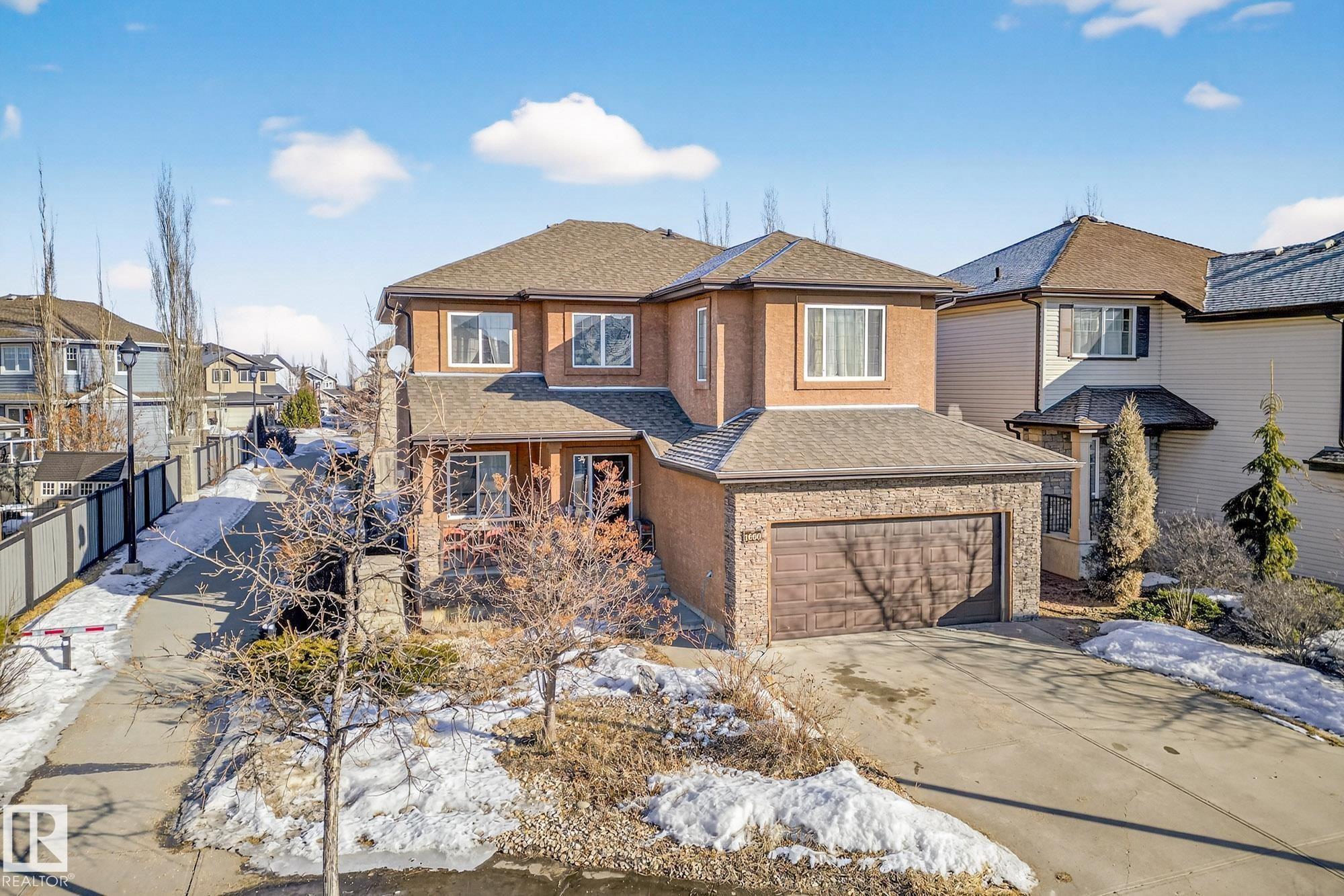 View of front facade featuring roof with shingles, concrete driveway, a garage, and a residential view - 1660 Malone Way, Edmonton, AB - Outdoor