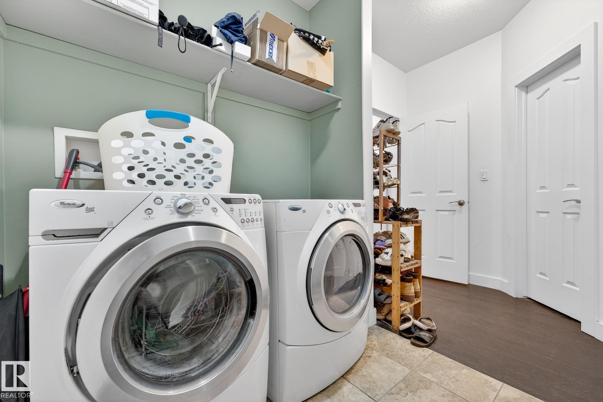 Laundry area with washing machine and dryer and light tile patterned floors - 1660 Malone Way, Edmonton, AB - Indoor Photo Showing Laundry Room