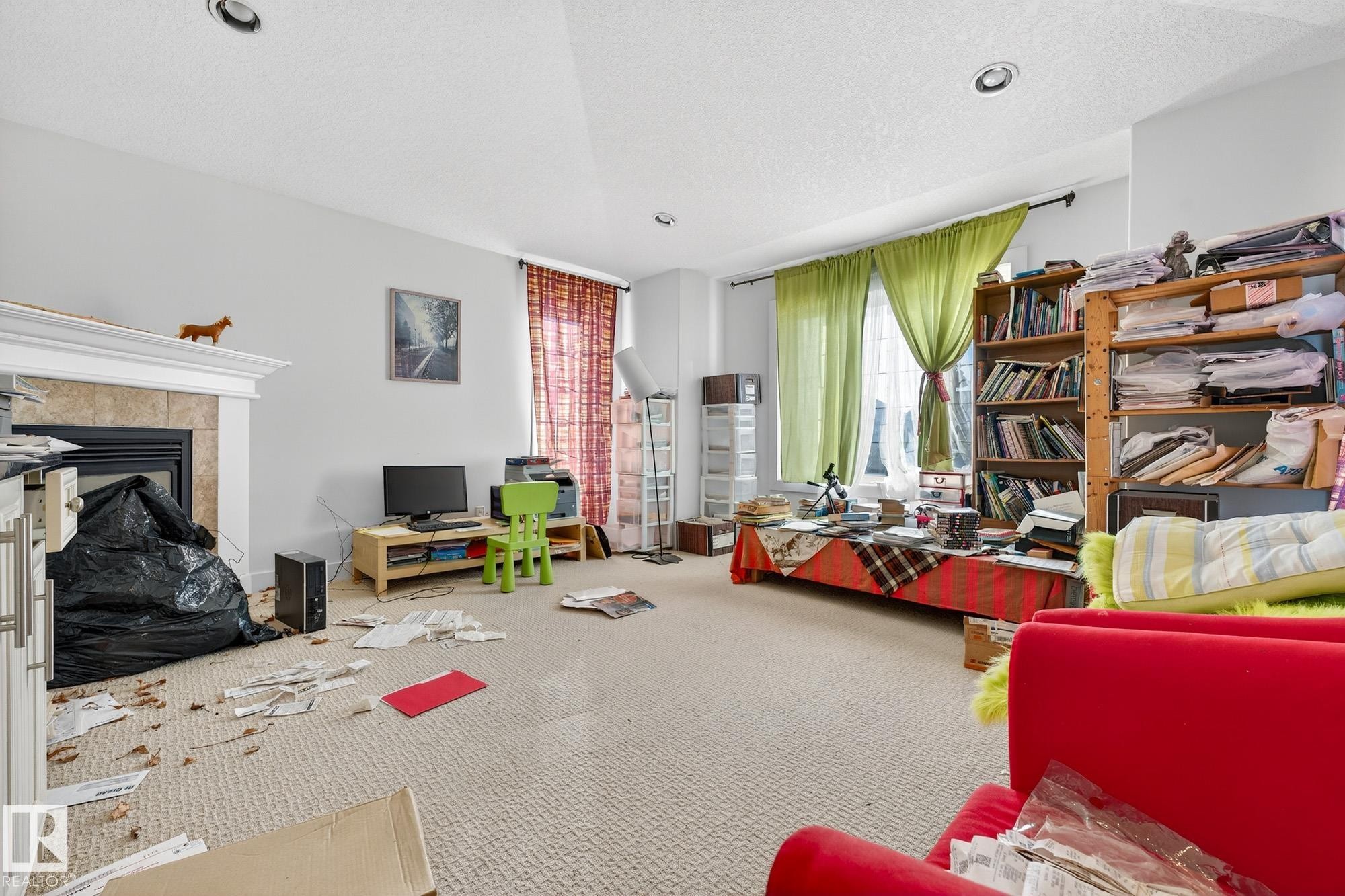 Carpeted living room featuring a fireplace and a textured ceiling - 1660 Malone Way, Edmonton, AB - Indoor Photo Showing Living Room With Fireplace