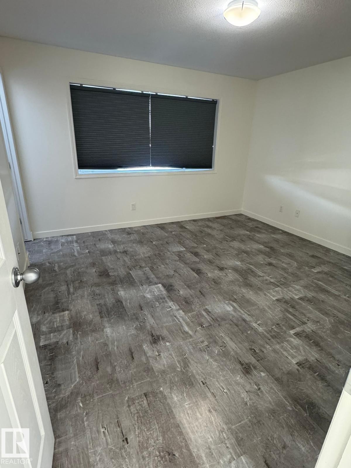 Unfurnished room featuring dark wood-style floors and a textured ceiling - 17703 65 Street, Edmonton, AB - Indoor Photo Showing Other Room