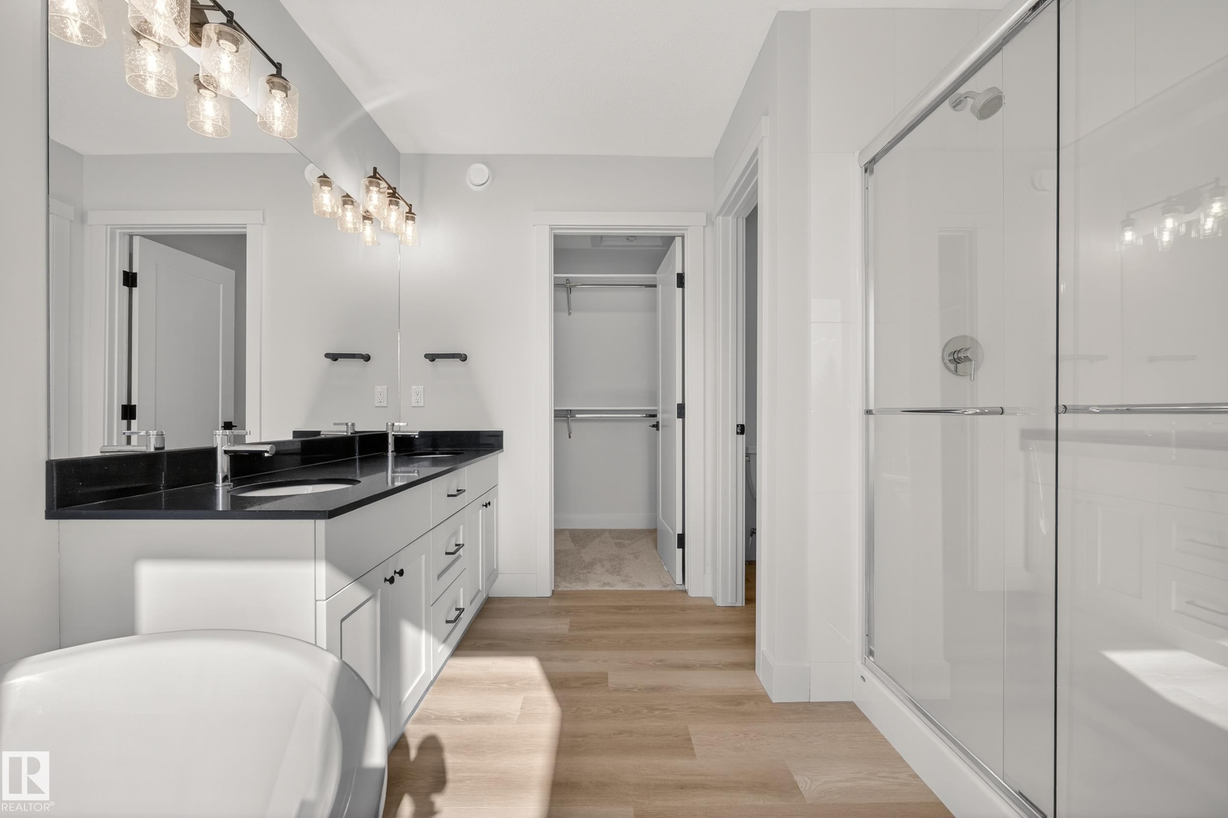 Bathroom with double vanity, a shower stall, light wood-style floors, and a walk in closet - 22 Grayson Green, Stony Plain, AB - Indoor Photo Showing Bathroom