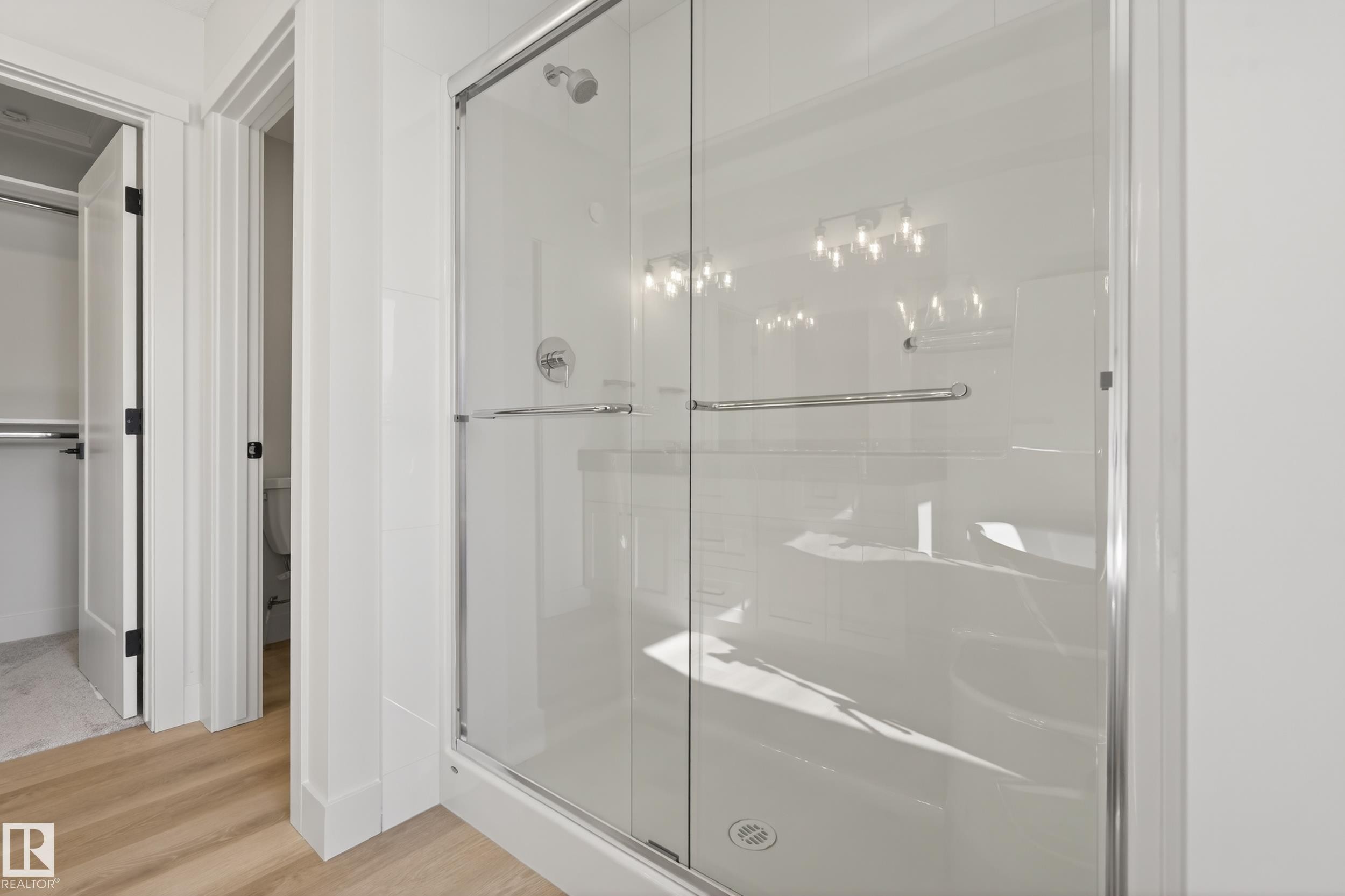 Full bathroom with a shower stall, light wood-type flooring, and a walk in closet - 22 Grayson Green, Stony Plain, AB - Indoor Photo Showing Bathroom