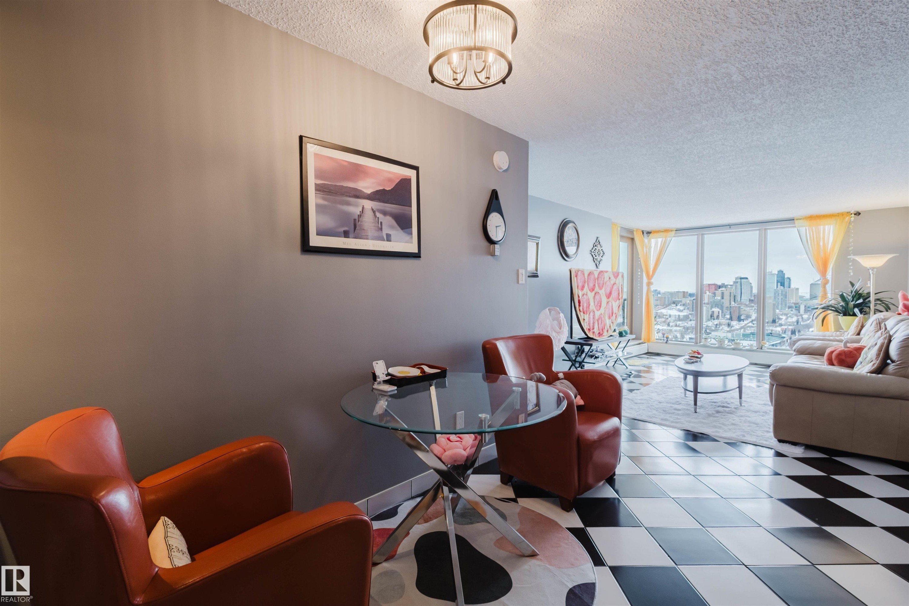 Living area with a textured ceiling, hanging lights, a view of skyline, and floor to ceiling windows - 1803 10149 Saskatchewan Drive, Edmonton, AB - Indoor Photo Showing Living Room