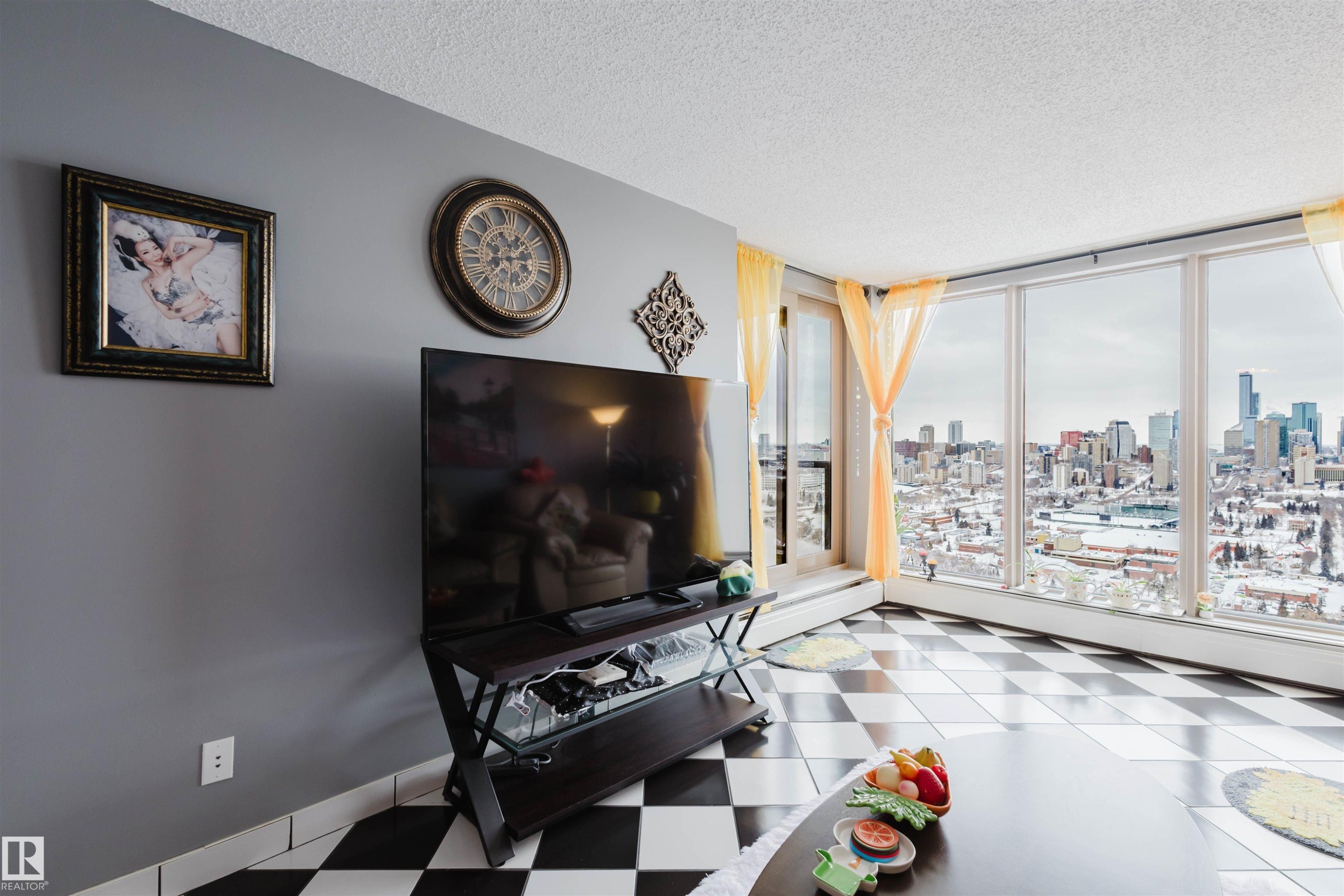 Living room featuring a textured ceiling, light flooring, and floor to ceiling windows - 1803 10149 Saskatchewan Drive, Edmonton, AB - Indoor Photo Showing Living Room