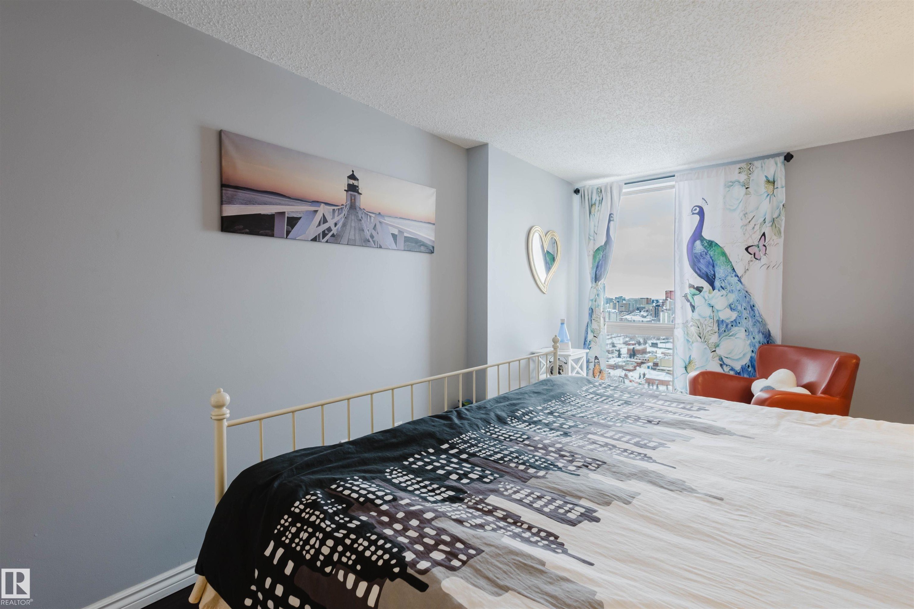 Bedroom featuring a textured ceiling and baseboards - 1803 10149 Saskatchewan Drive, Edmonton, AB - Indoor Photo Showing Bedroom