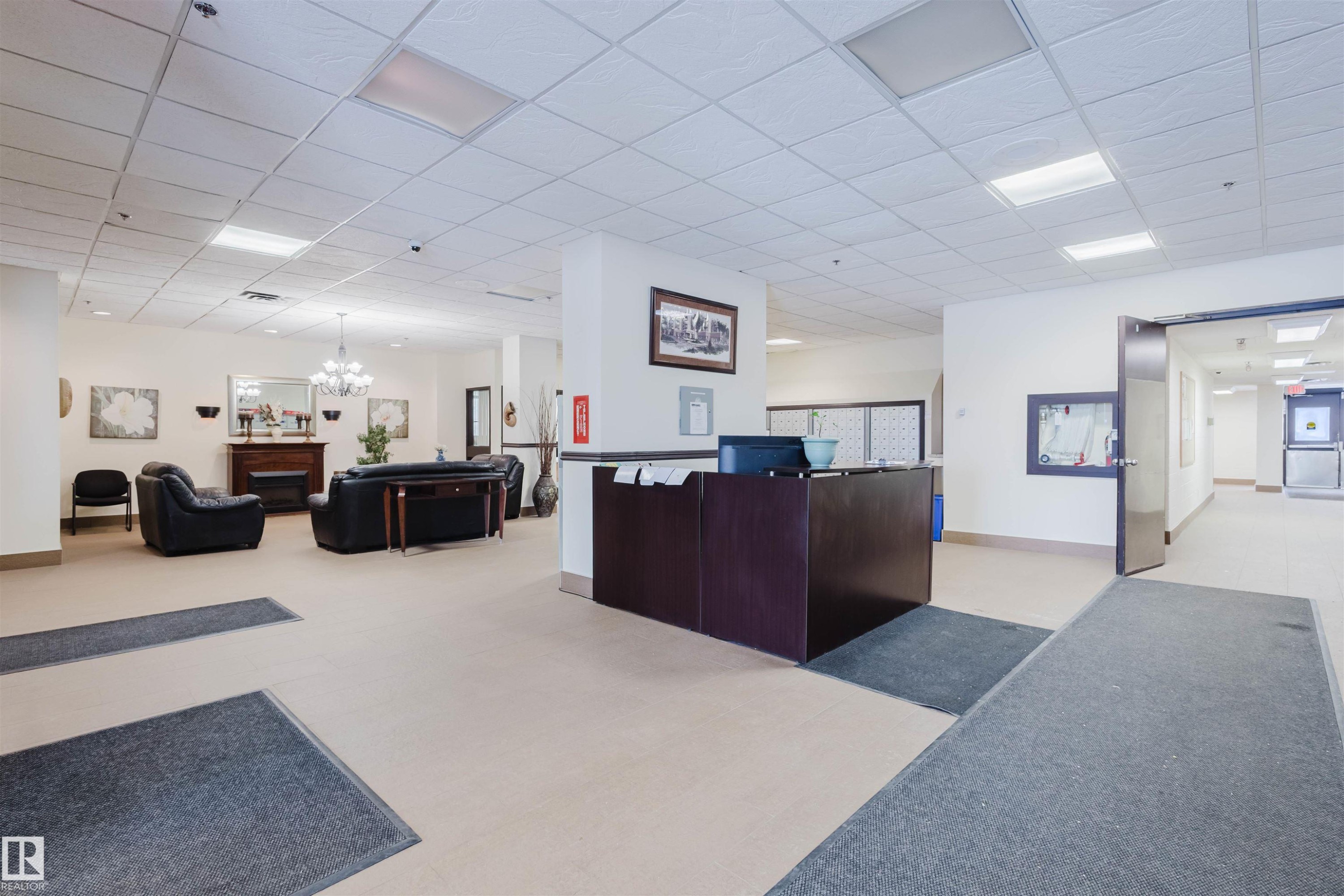 Reception featuring a paneled ceiling, hanging lights, and a fireplace - 1803 10149 Saskatchewan Drive, Edmonton, AB - Indoor Photo Showing Other Room