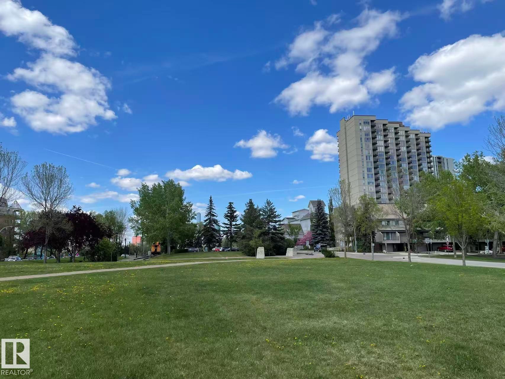 Expansive green space with a walking path, surrounded by mature trees and views of nearby buildings - 1803 10149 Saskatchewan Drive, Edmonton, AB - Outdoor