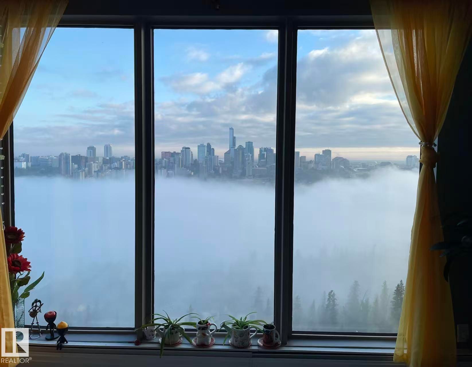 Expansive windows offer scenic views of the city skyline and natural landscape - 1803 10149 Saskatchewan Drive, Edmonton, AB - Photo Showing Other Room With Body Of Water