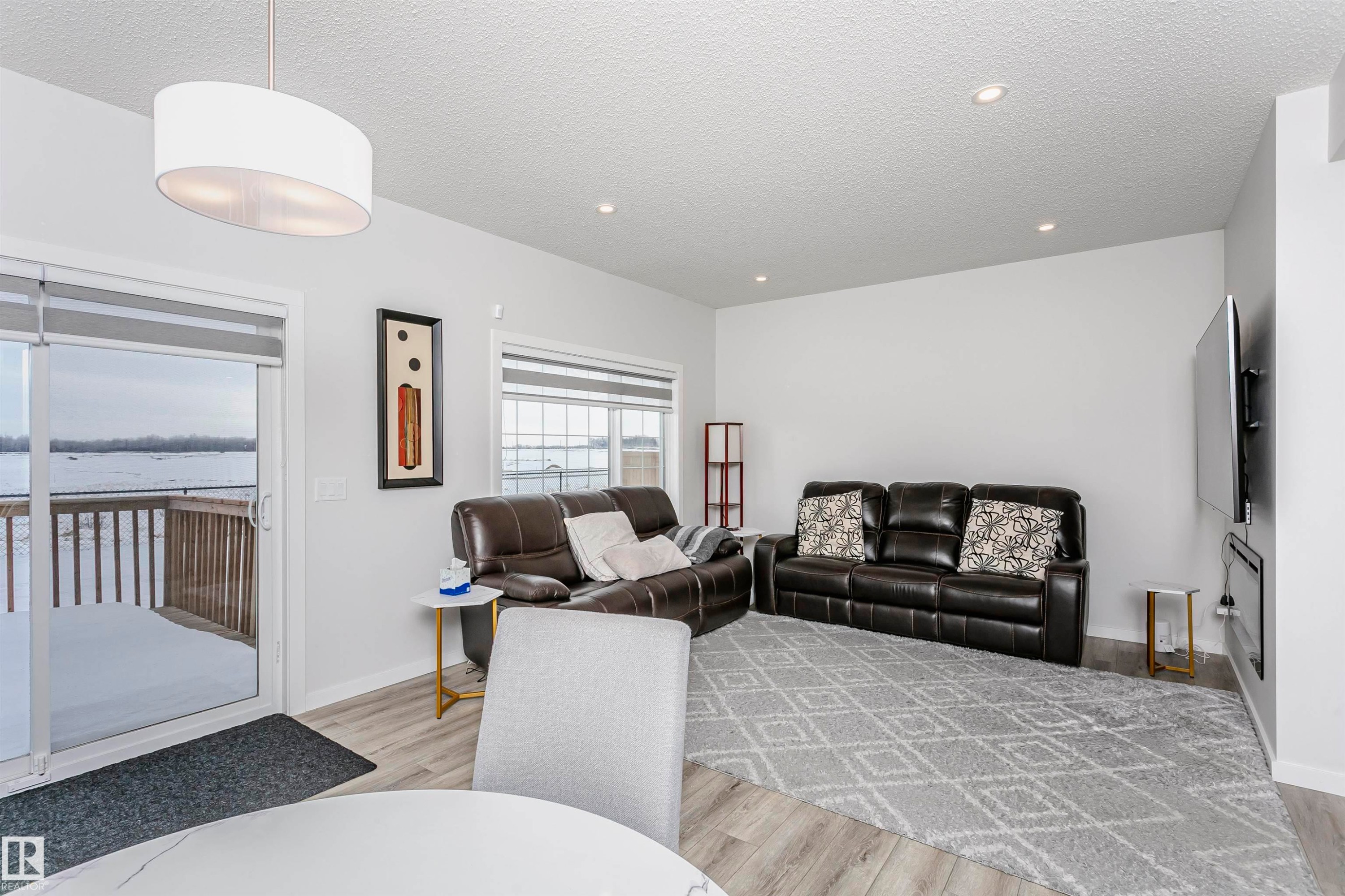 Living area featuring a textured ceiling, light wood-style floors, and recessed lighting - 9421 Pear Crescent, Edmonton, AB - Indoor
