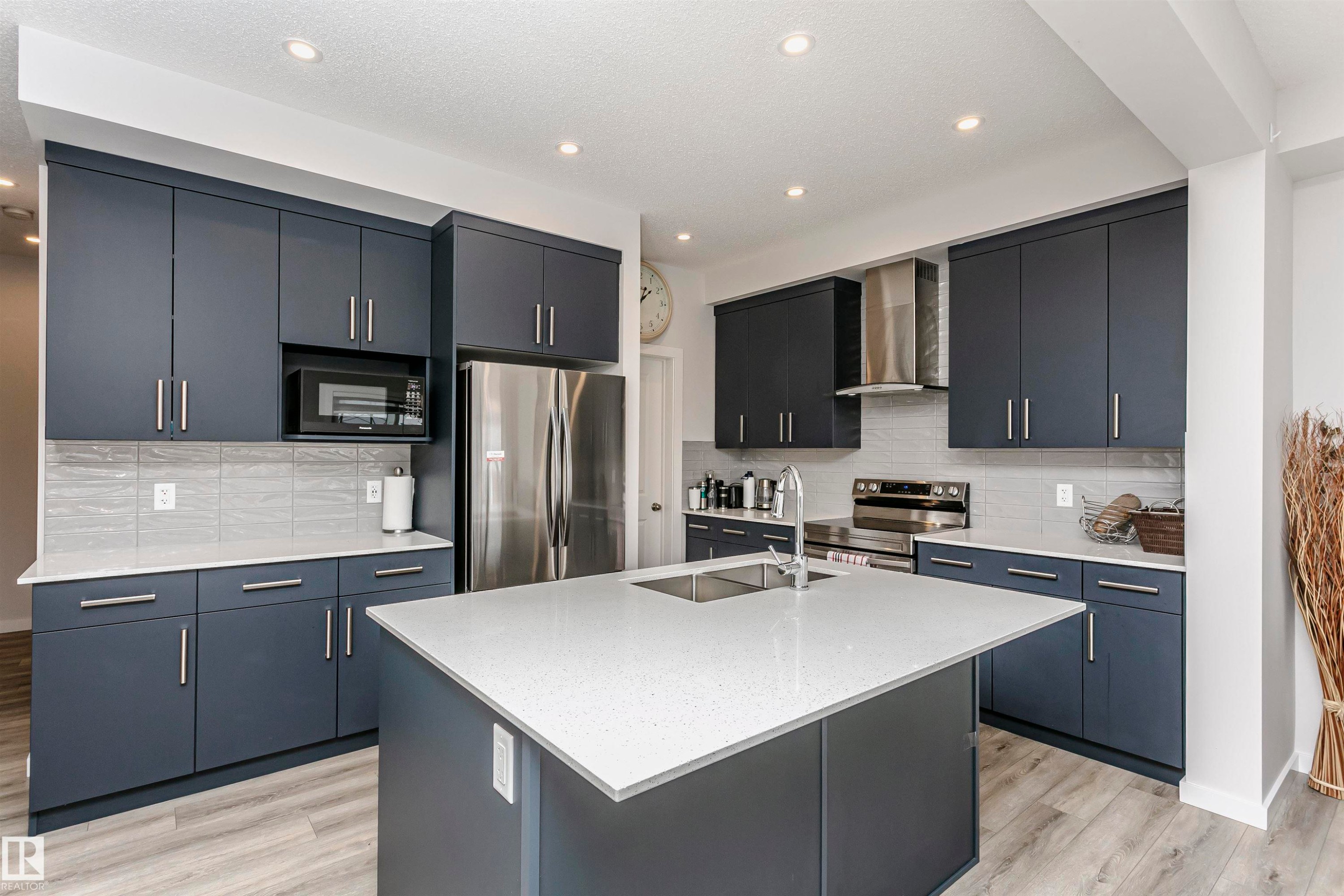 Kitchen with stainless steel appliances, light stone counters, decorative backsplash, an island with sink, and recessed lighting - 9421 Pear Crescent, Edmonton, AB - Indoor Photo Showing Kitchen With Stainless Steel Kitchen With Double Sink With Upgraded Kitchen
