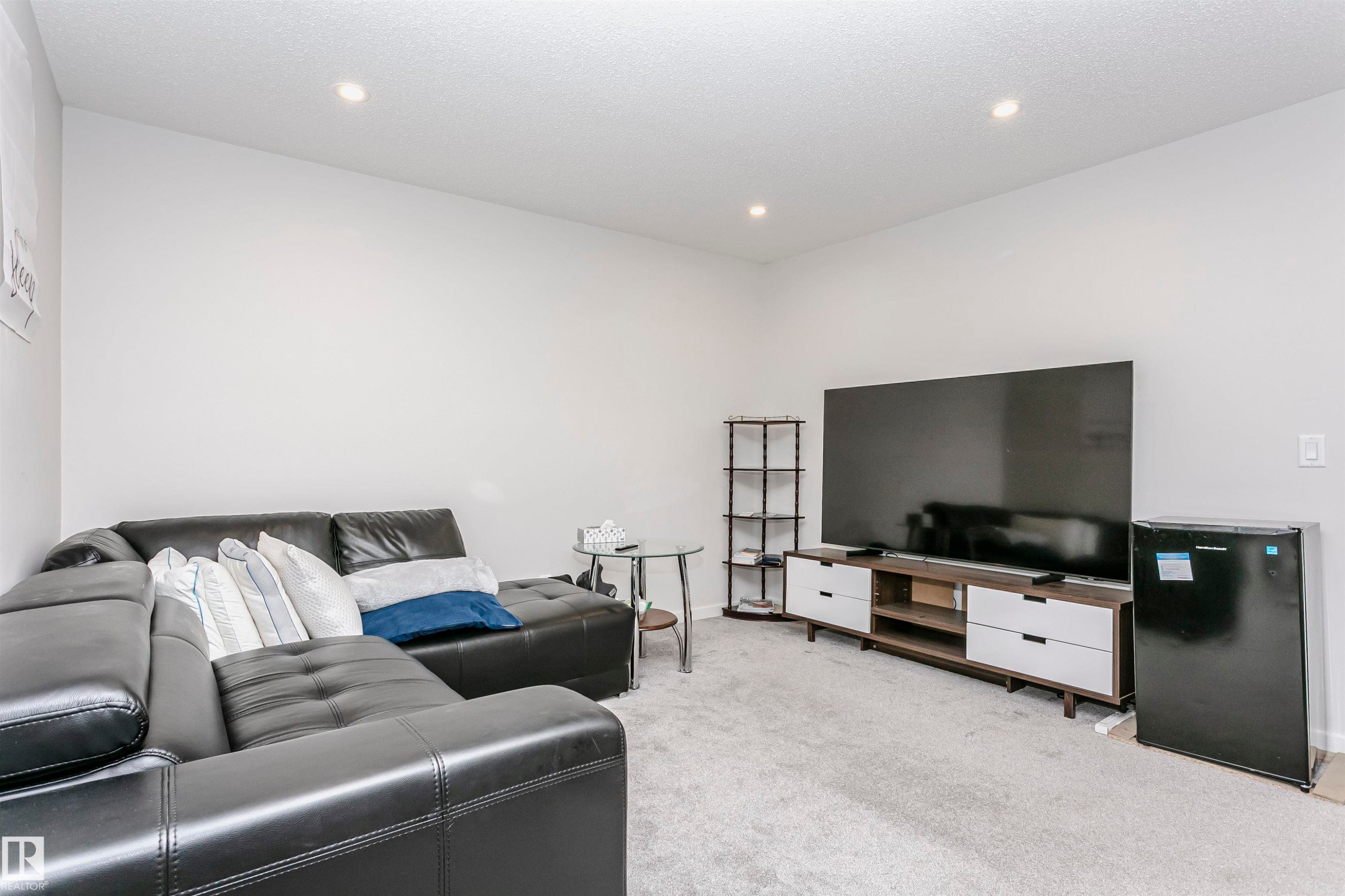 Living room featuring light colored carpet, recessed lighting, and a textured ceiling - 9421 Pear Crescent, Edmonton, AB - Indoor Photo Showing Living Room