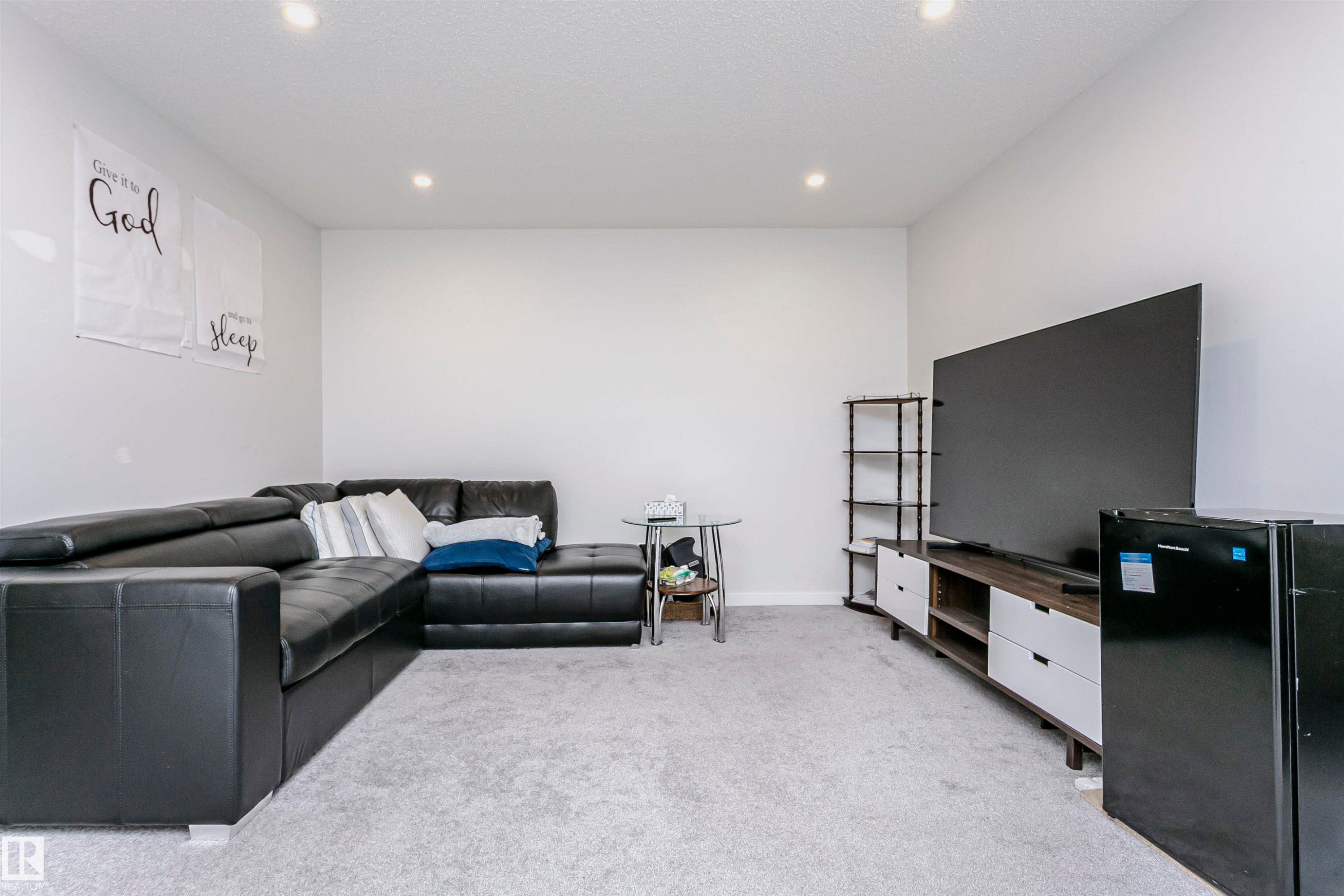 Living room with light carpet, recessed lighting, and a textured ceiling - 9421 Pear Crescent, Edmonton, AB - Indoor