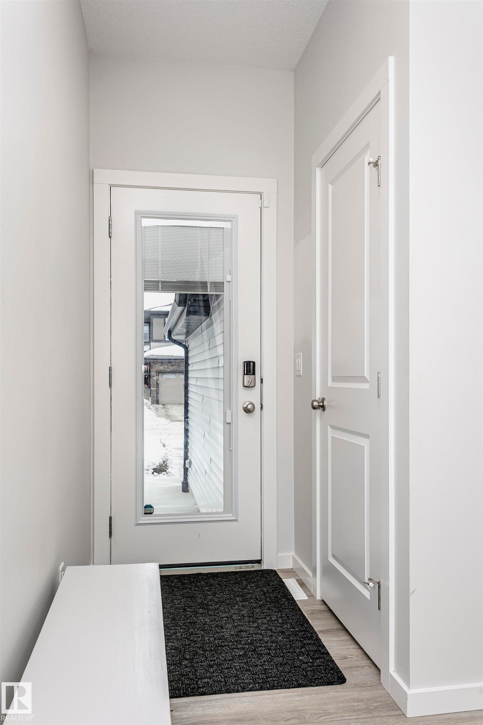 Doorway to outside with wood finished floors and baseboards - 9421 Pear Crescent, Edmonton, AB - Indoor Photo Showing Other Room