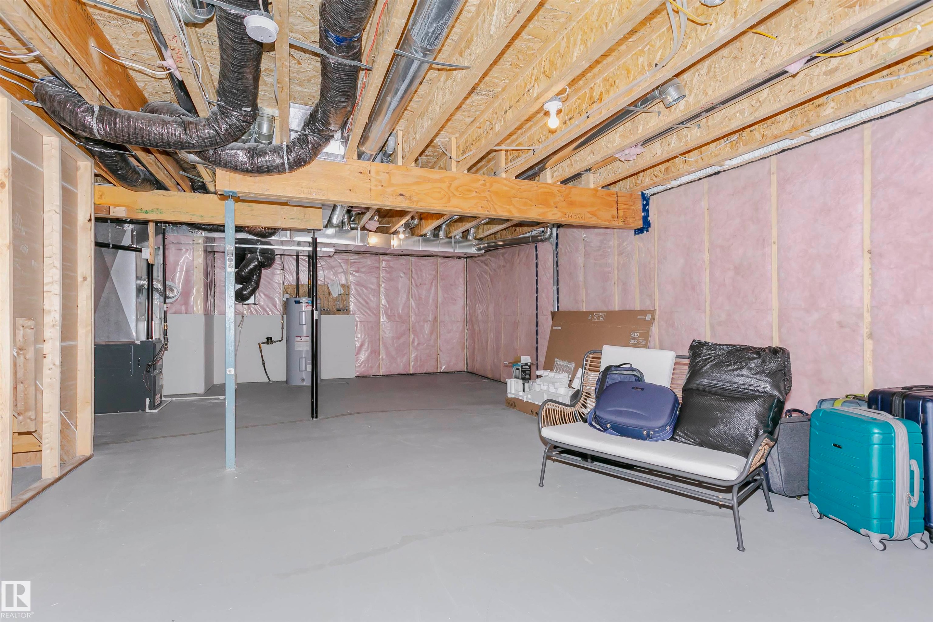 Unfinished basement featuring electric water heater and washer / dryer - 9421 Pear Crescent, Edmonton, AB - Indoor Photo Showing Basement