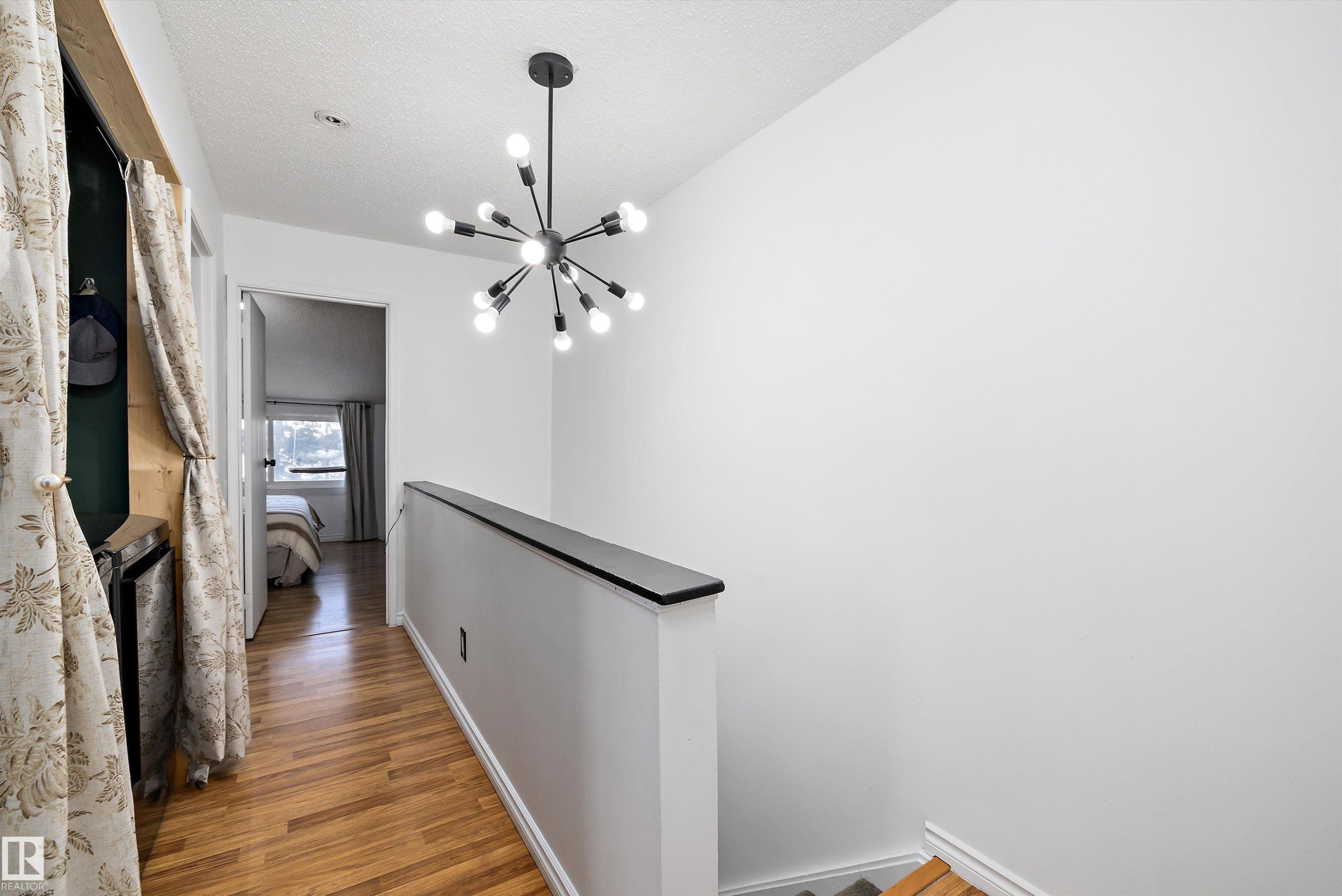 Hall featuring an upstairs landing, a chandelier, and light wood-type flooring - 139 Lancaster Terrace, Edmonton, AB - Indoor Photo Showing Other Room