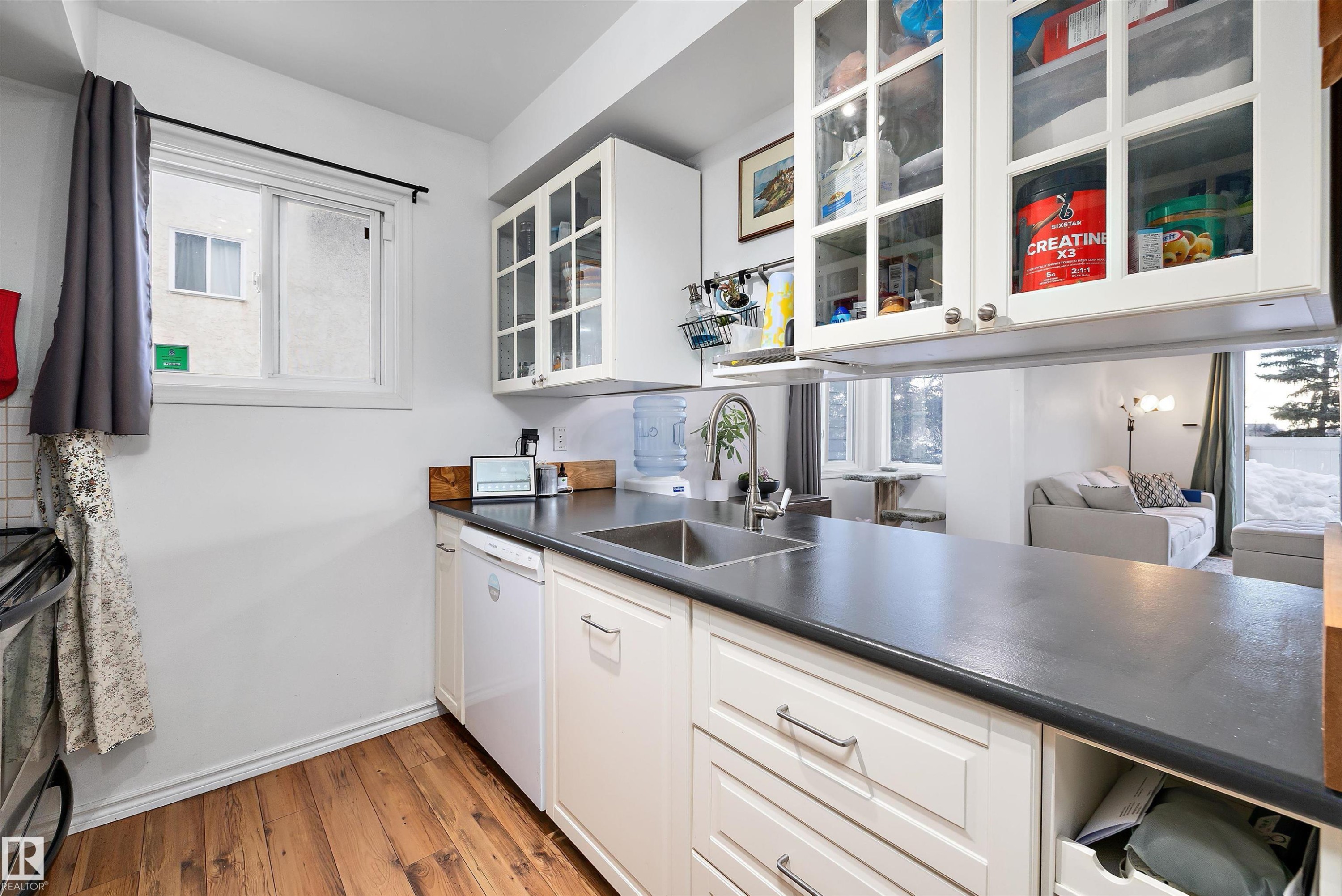 Kitchen with dark countertops, healthy amount of natural light, and white cabinets - 139 Lancaster Terrace, Edmonton, AB - Indoor Photo Showing Kitchen