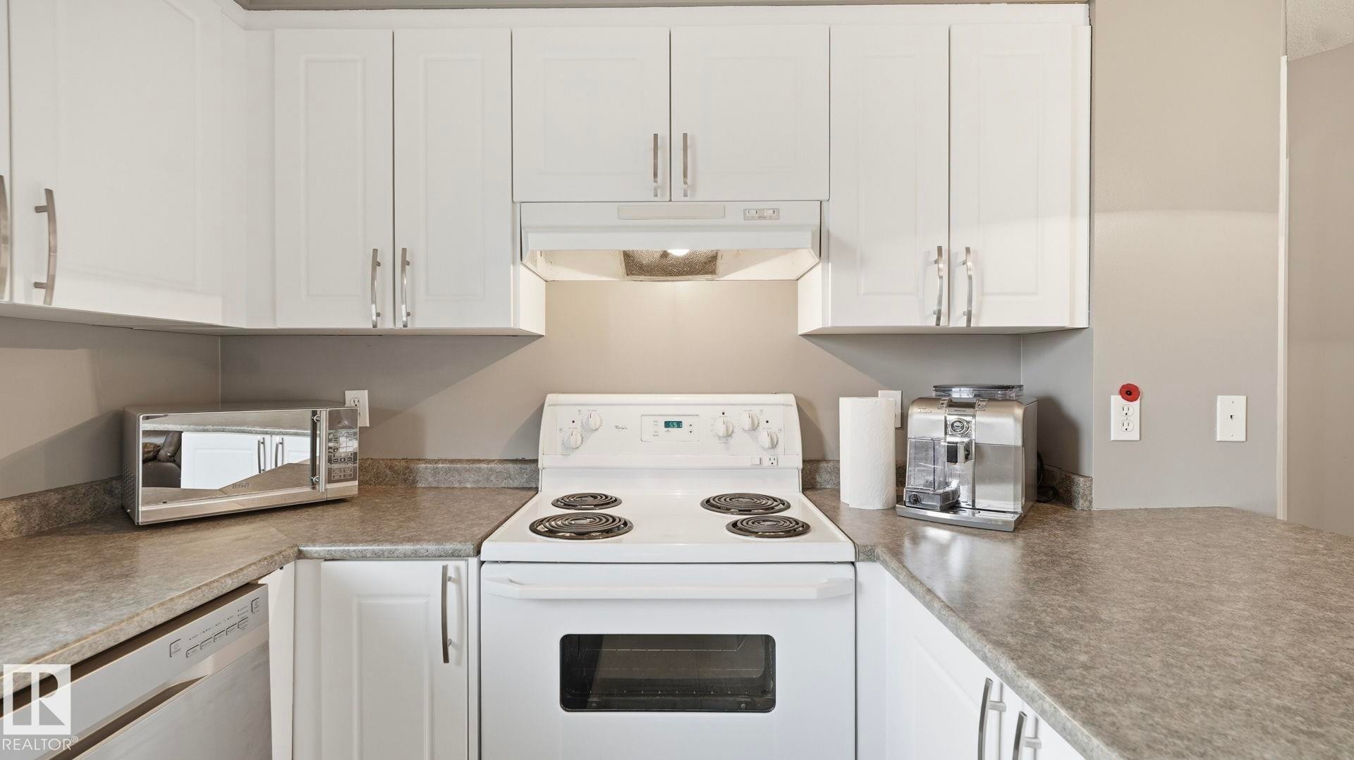 Kitchen with stainless steel appliances and white cabinetry - 401 636 Mcallister Loop, Edmonton, AB - Indoor Photo Showing Kitchen