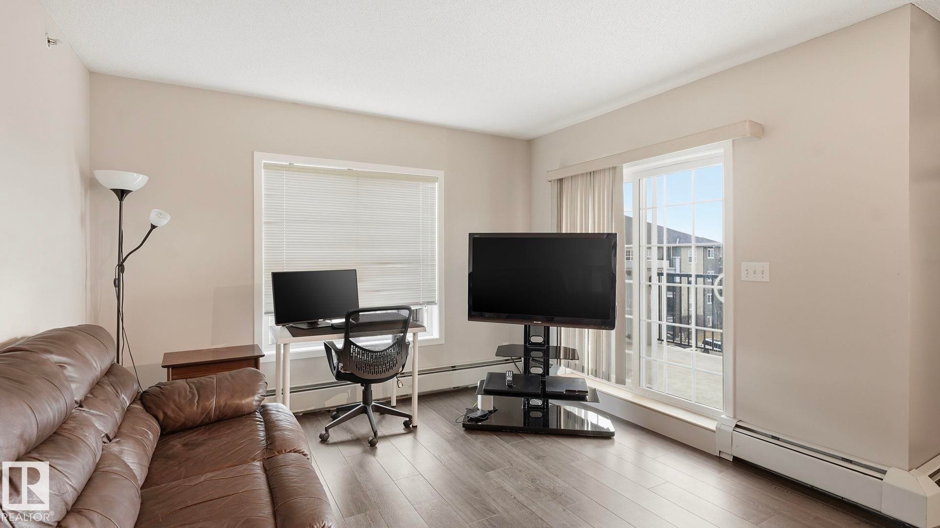 Office area with a baseboard radiator and wood finished floors - 401 636 Mcallister Loop, Edmonton, AB - Indoor Photo Showing Office