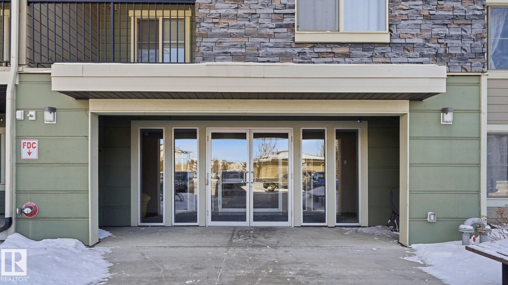 Snow covered property entrance with stone siding - 319 274 Mcconachie Drive, Edmonton, AB - Outdoor