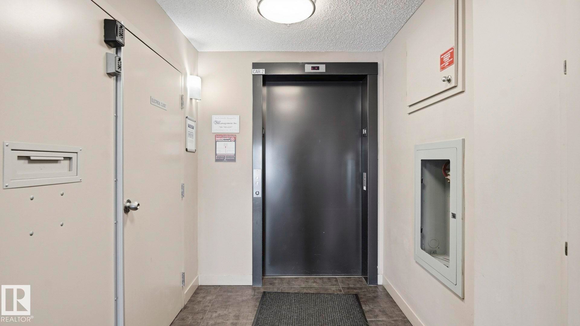 Hallway with elevator and a textured ceiling - 319 274 Mcconachie Drive, Edmonton, AB - Indoor Photo Showing Other Room