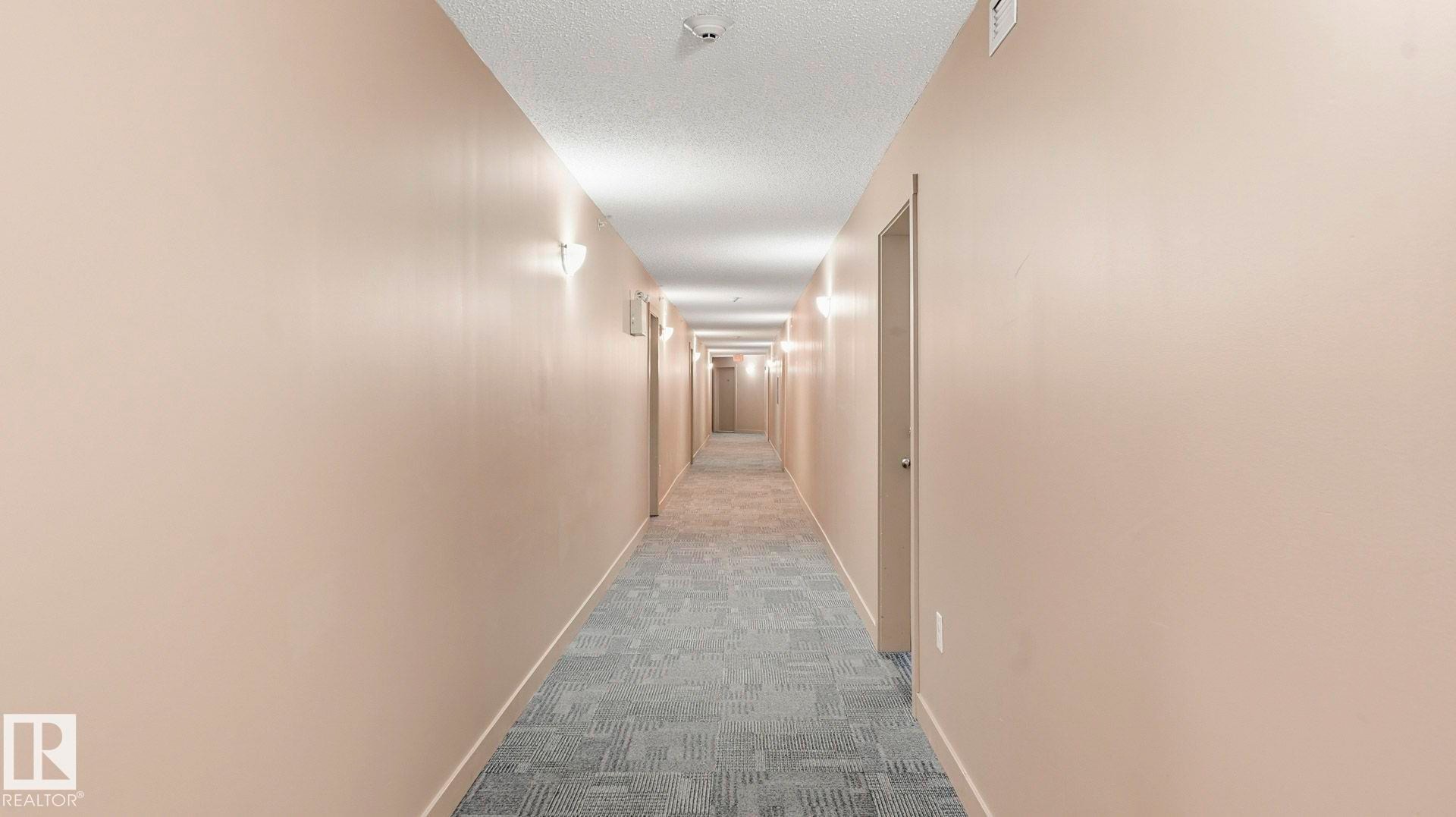 Hall featuring dark colored carpet and a textured ceiling - 319 274 Mcconachie Drive, Edmonton, AB - Indoor Photo Showing Other Room