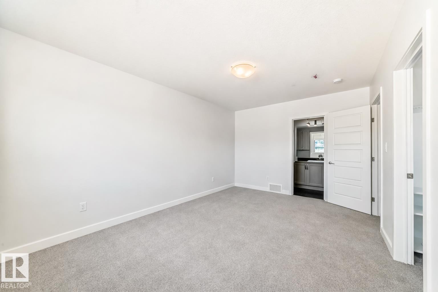 Unfurnished bedroom featuring light carpet and ensuite bath - 2282 Chokecherry Close, Edmonton, AB - Indoor Photo Showing Other Room